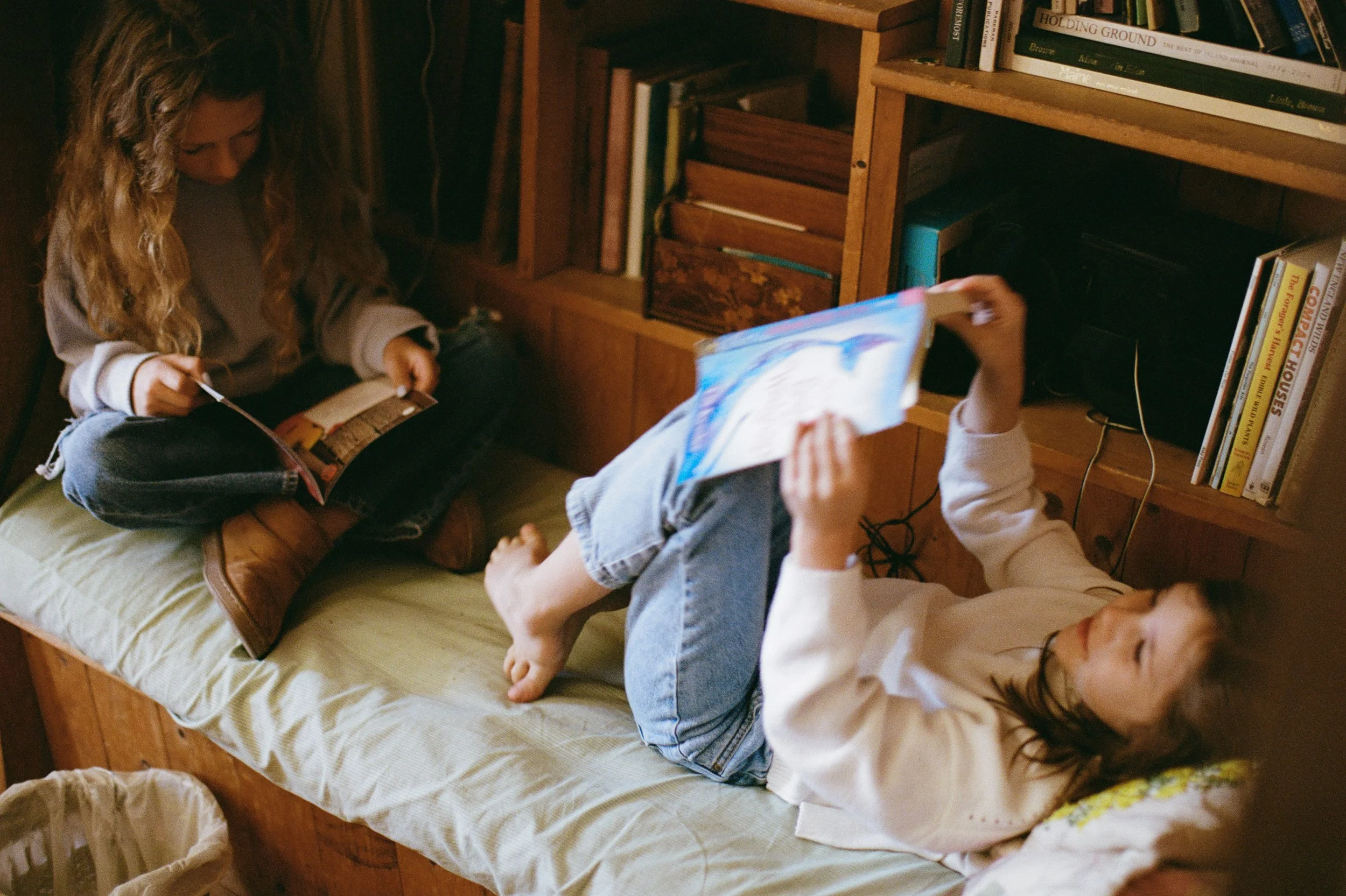Kids read books during a visit with family to Southwest Harbor, Maine. Film photography by Sienna Renee Photography.