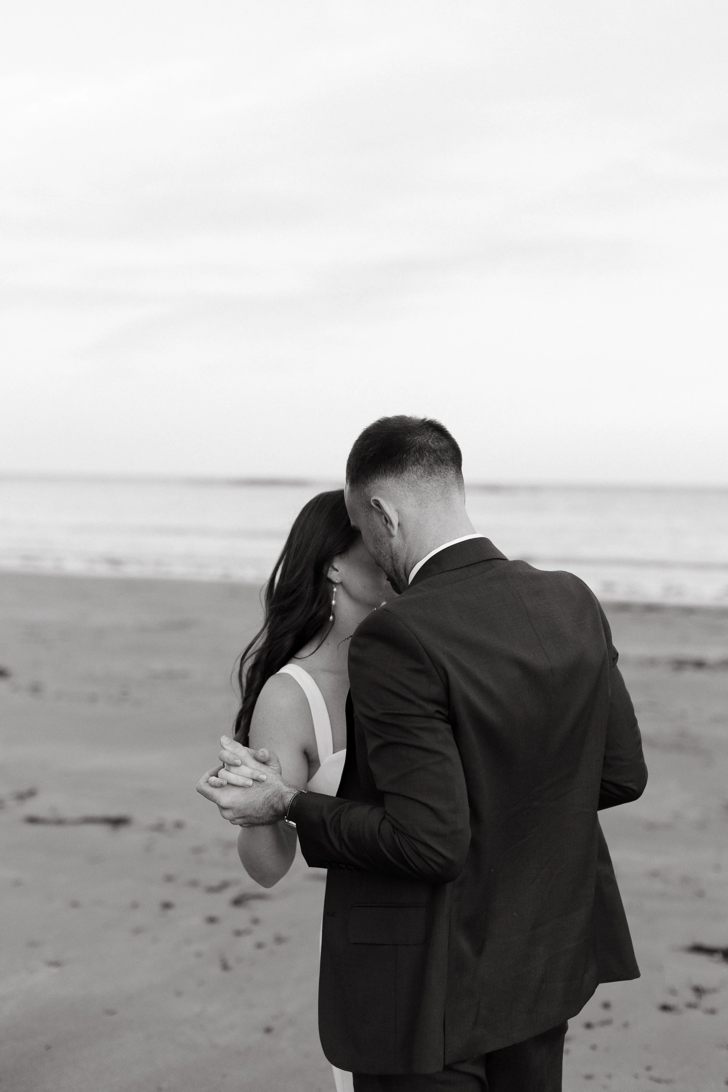 A couple dance together on the beach during their wedding in York, Maine. Photography by Sienna Renee Photography.