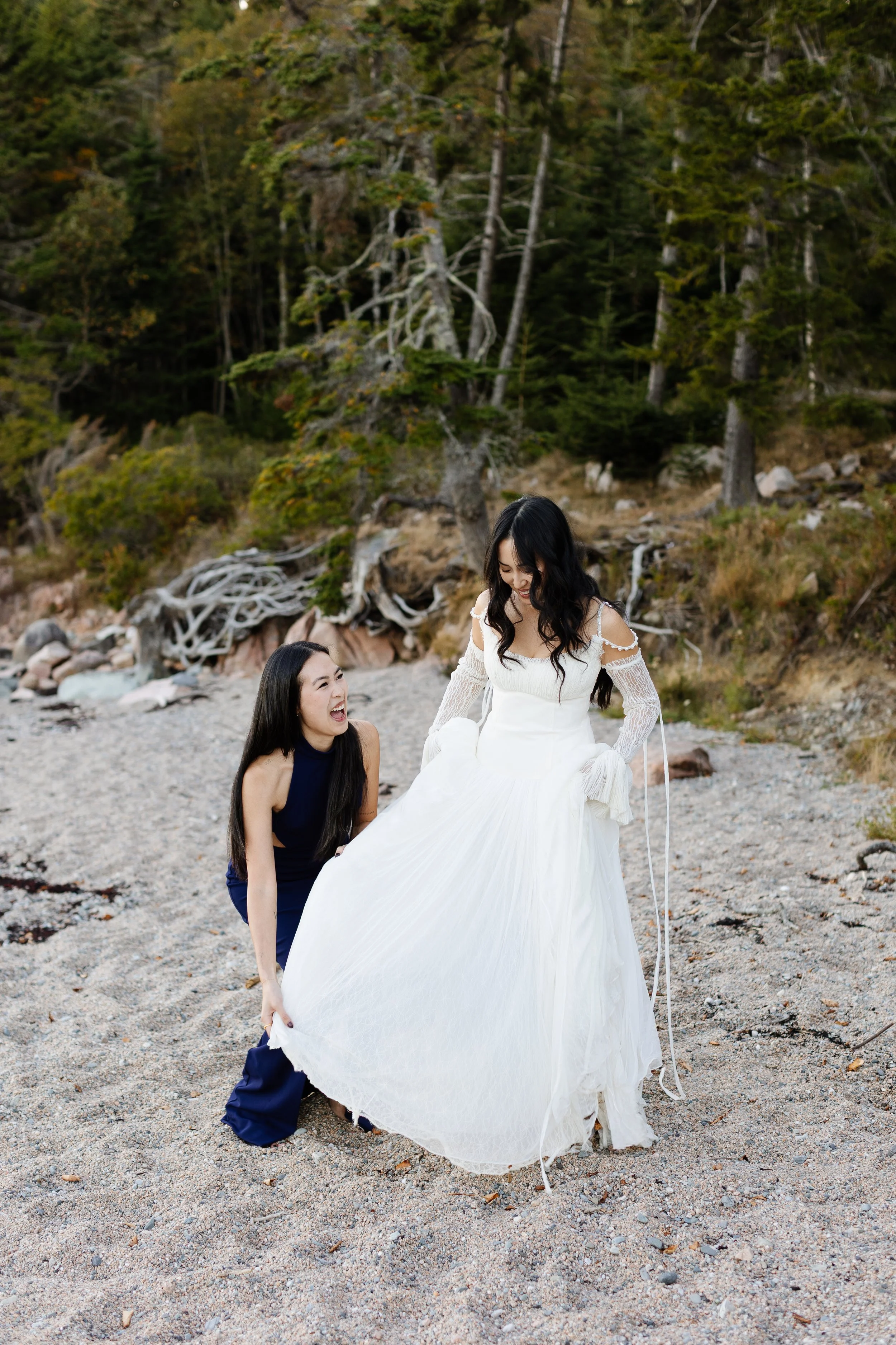 A bride and her sister laugh together during an intimate wedding weekend at Aragosta at Goose Cove in Deer Isle, Maine. Photography by Sienna Renee Photography.