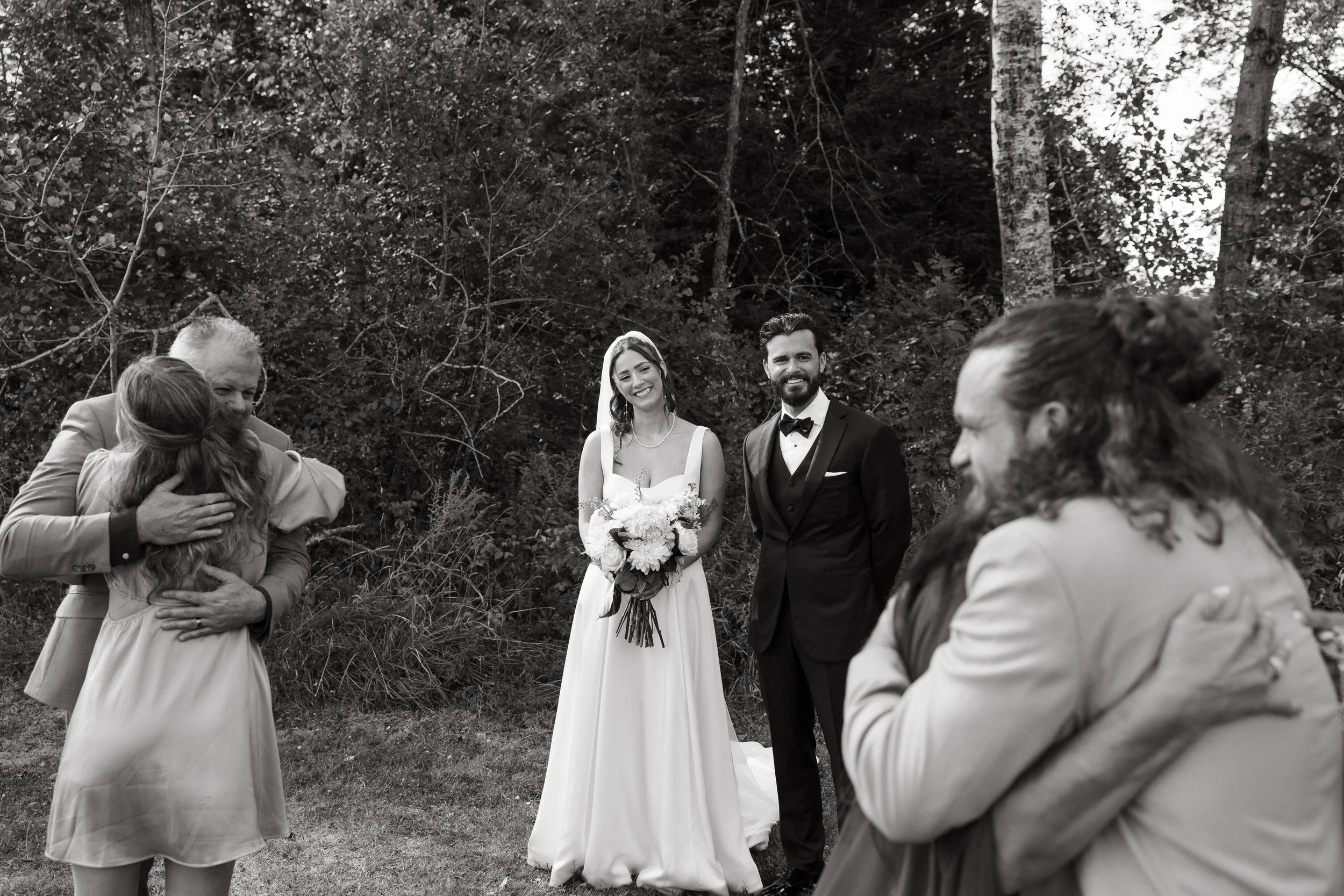 Family hugs during small backyard wedding in Palmyra, Maine. Photography by Sienna Renee Photography.