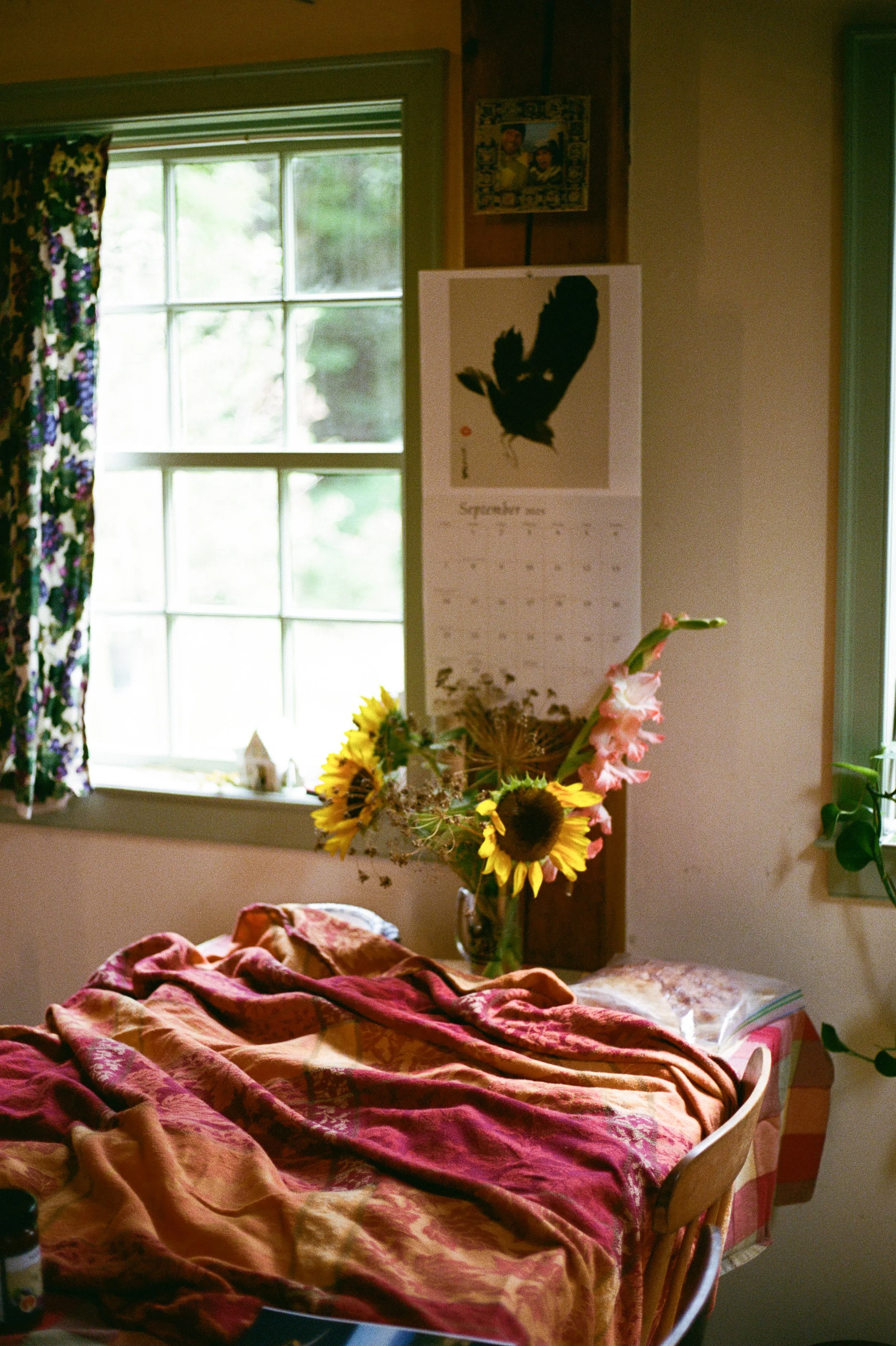 A table and flowers in a home during a small backyard wedding in Maine. Photography by Sienna Renee Photography.