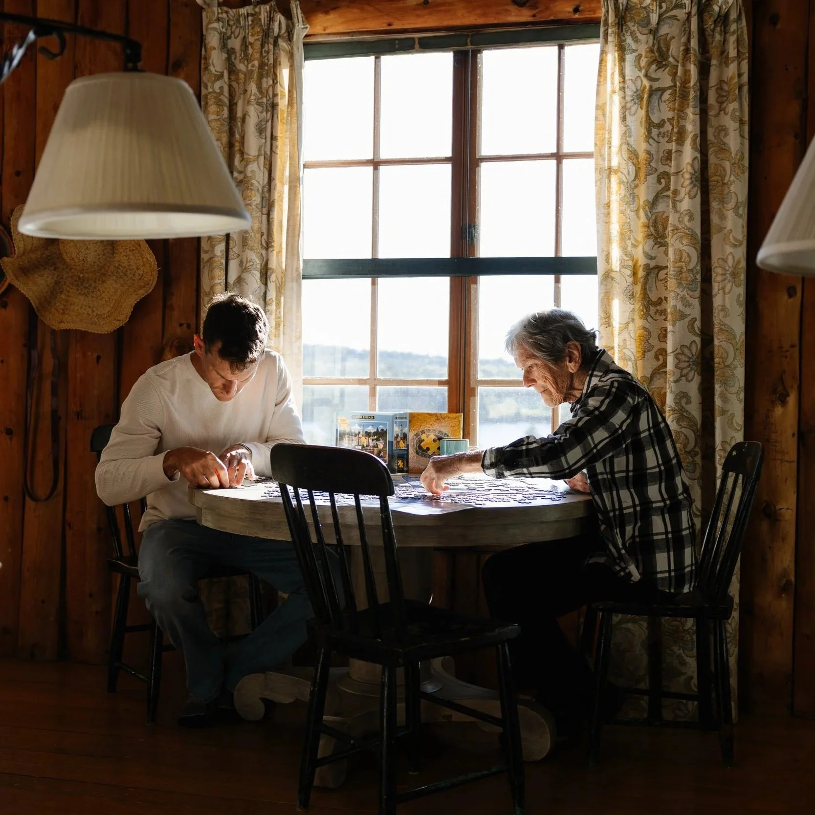 Family puzzle in a living room during photo session and a visit to Maine. Photography by Sienna Renee Photography.