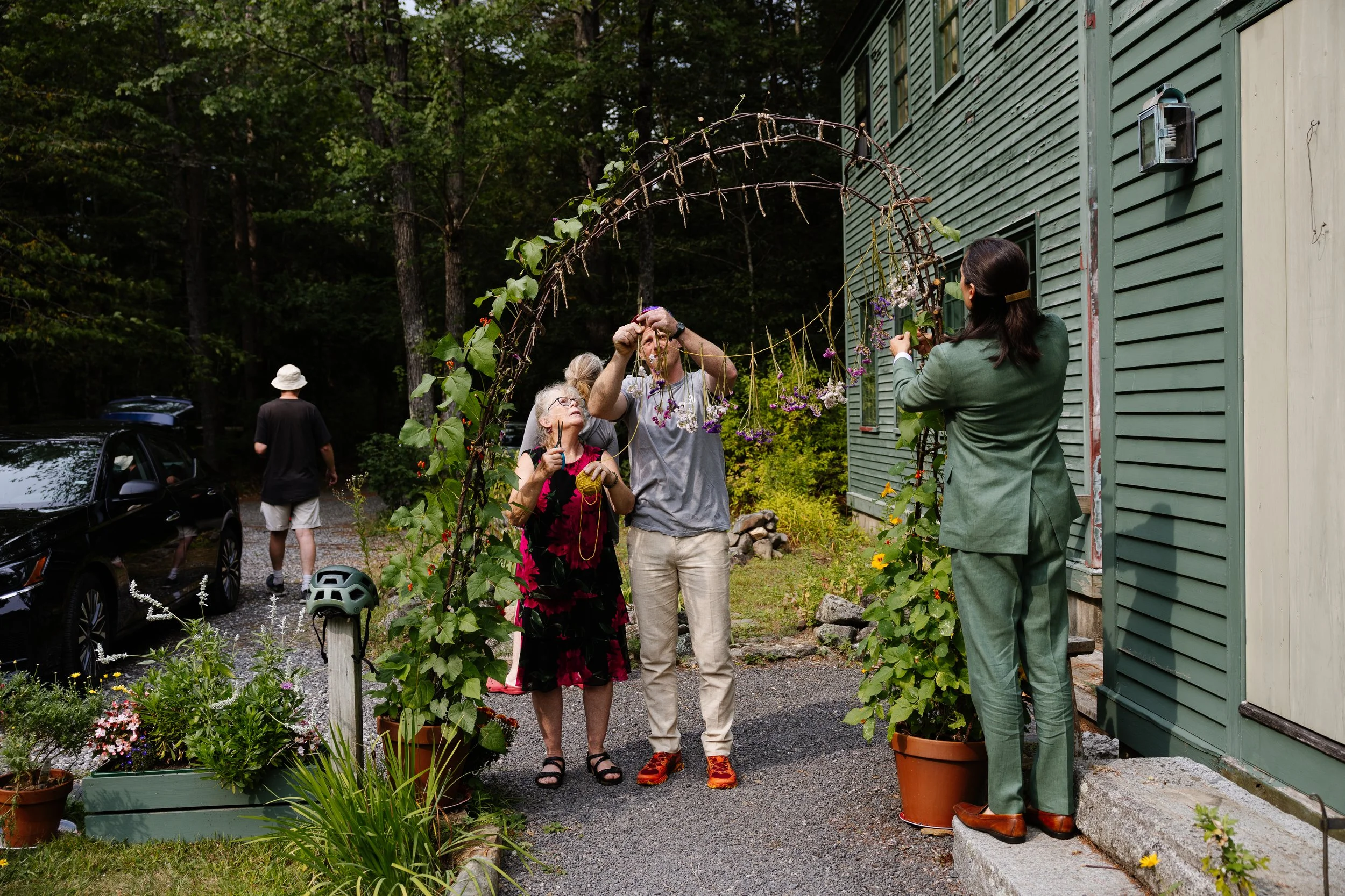 A family helps set up during an intimate backyard wedding in Maine. Photography by Sienna Renee Photography.