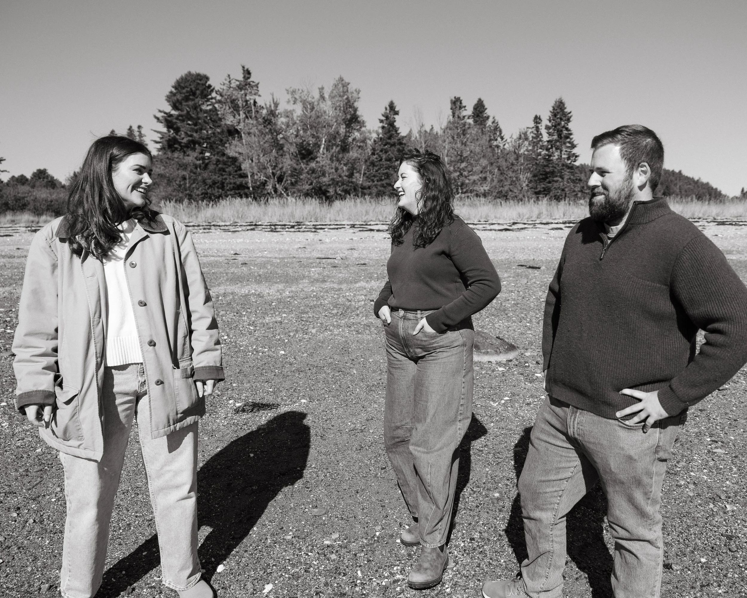 Family laugh on a beach in Southwest Harbor, Maine while looking for rocks. Photography by Sienna Renee Photography.