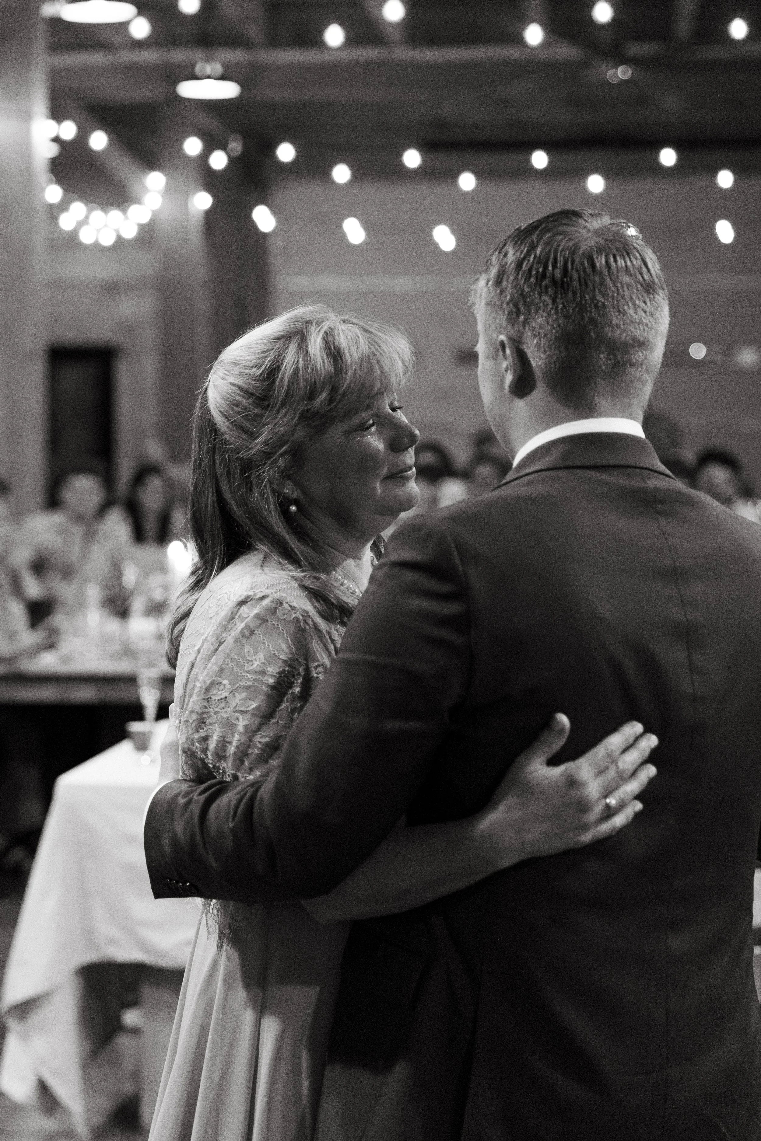 A mom and son dance during a small backyard wedding in Dover-Foxcroft, Maine. Photography by Sienna Renee Photography.