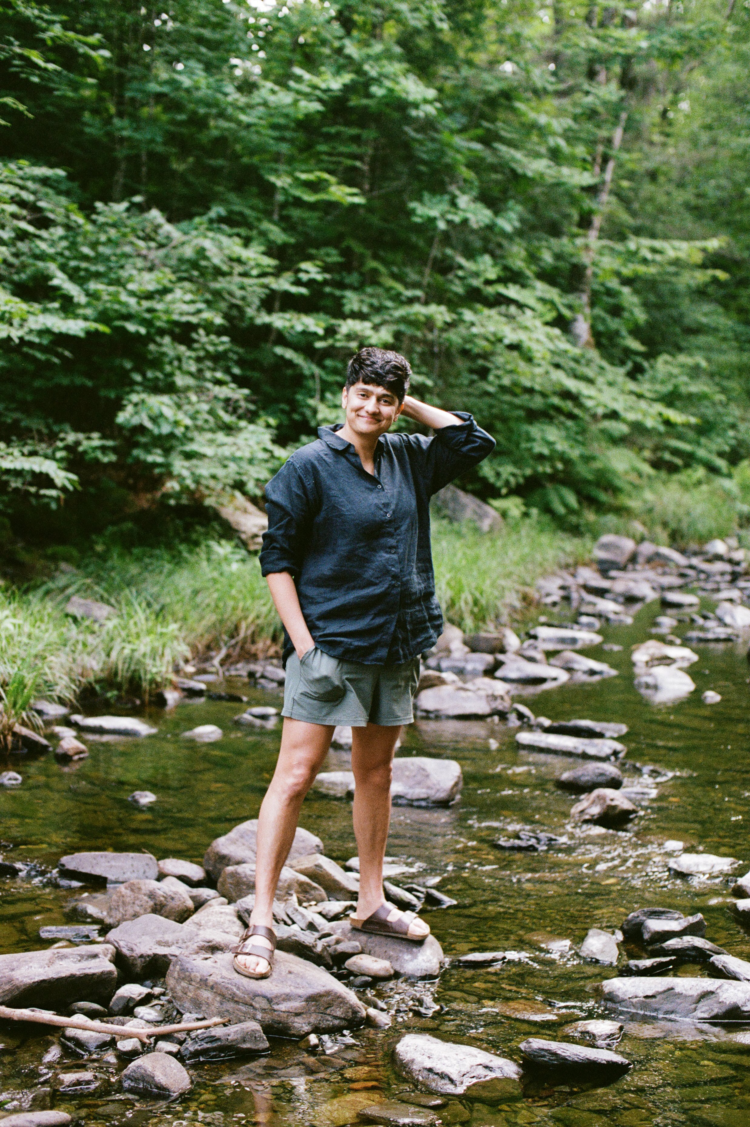 A couple during a babymoon in the Moosehead Lake Region of Maine walk by the river. Photography by Sienna Renee Photography.