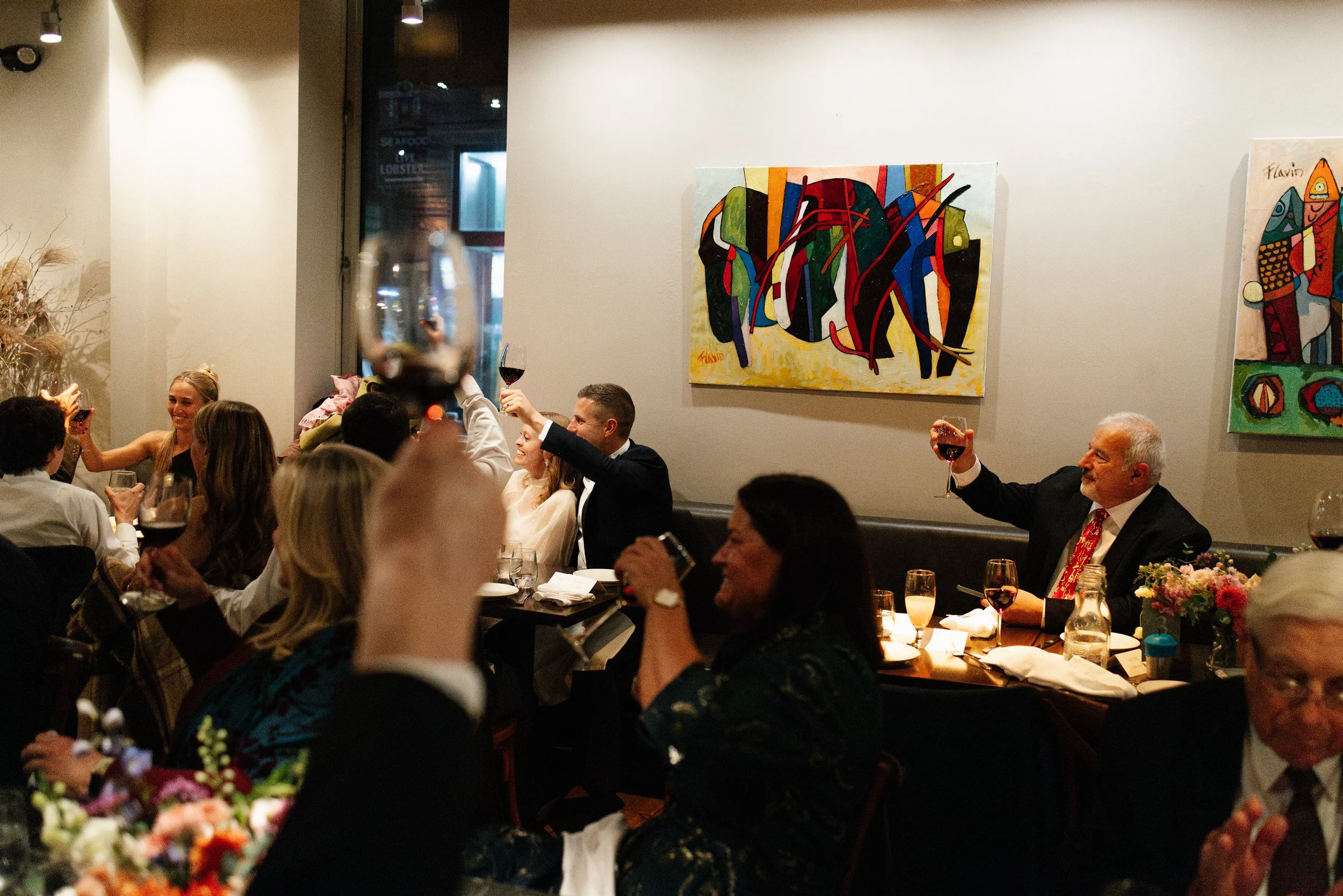 A couple and their guests toast during their wedding reception at Solo Italiano in Maine. Photography by Sienna Renee Photography.