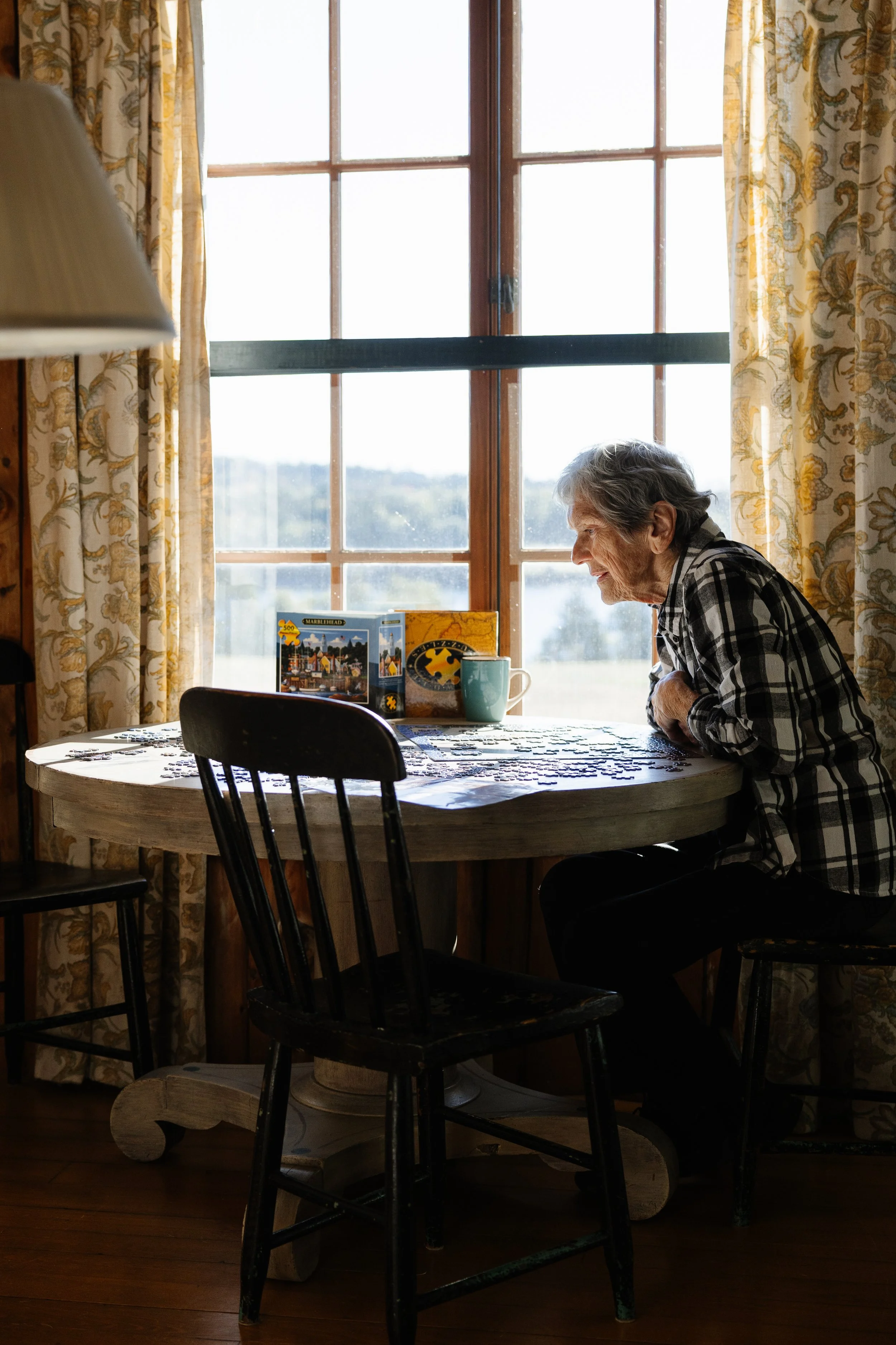 Family together at a rental one morning in Southwest Harbor, Maine while puzzling. Photography by Sienna Renee Photography.