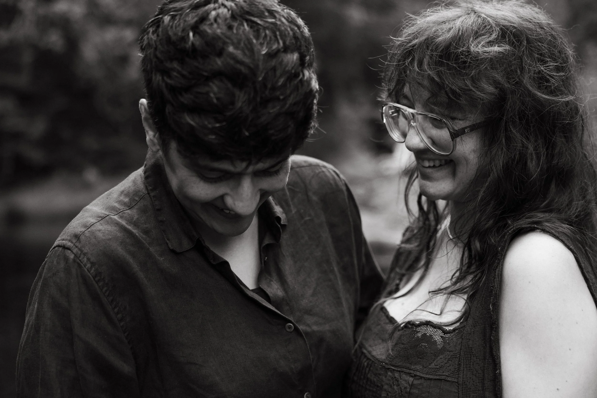 A couple laughs and holds each other close during their babymoon in Moosehead Lake, Maine. Photography by Sienna Renee Photography.