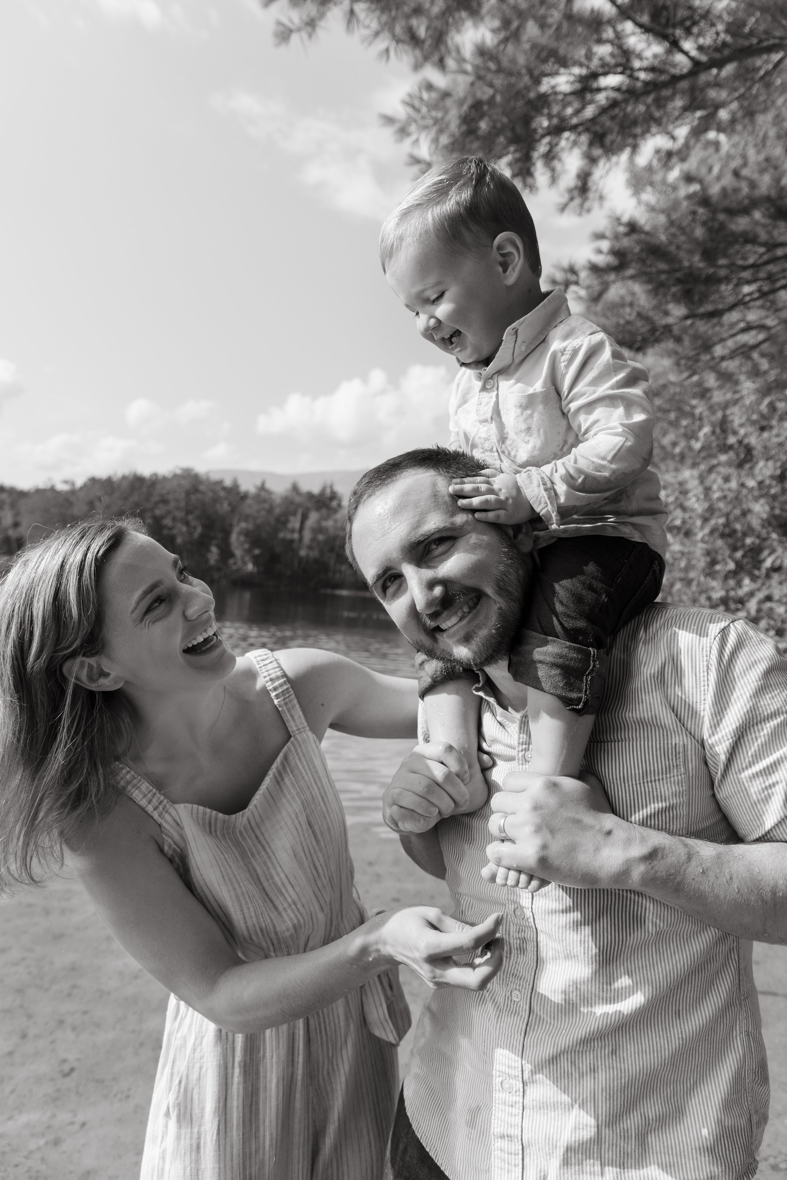 A couple laughs with their baby during a camping trip near Baxter State Park in Millinocket, Maine. Photography by Sienna Renee Photography.