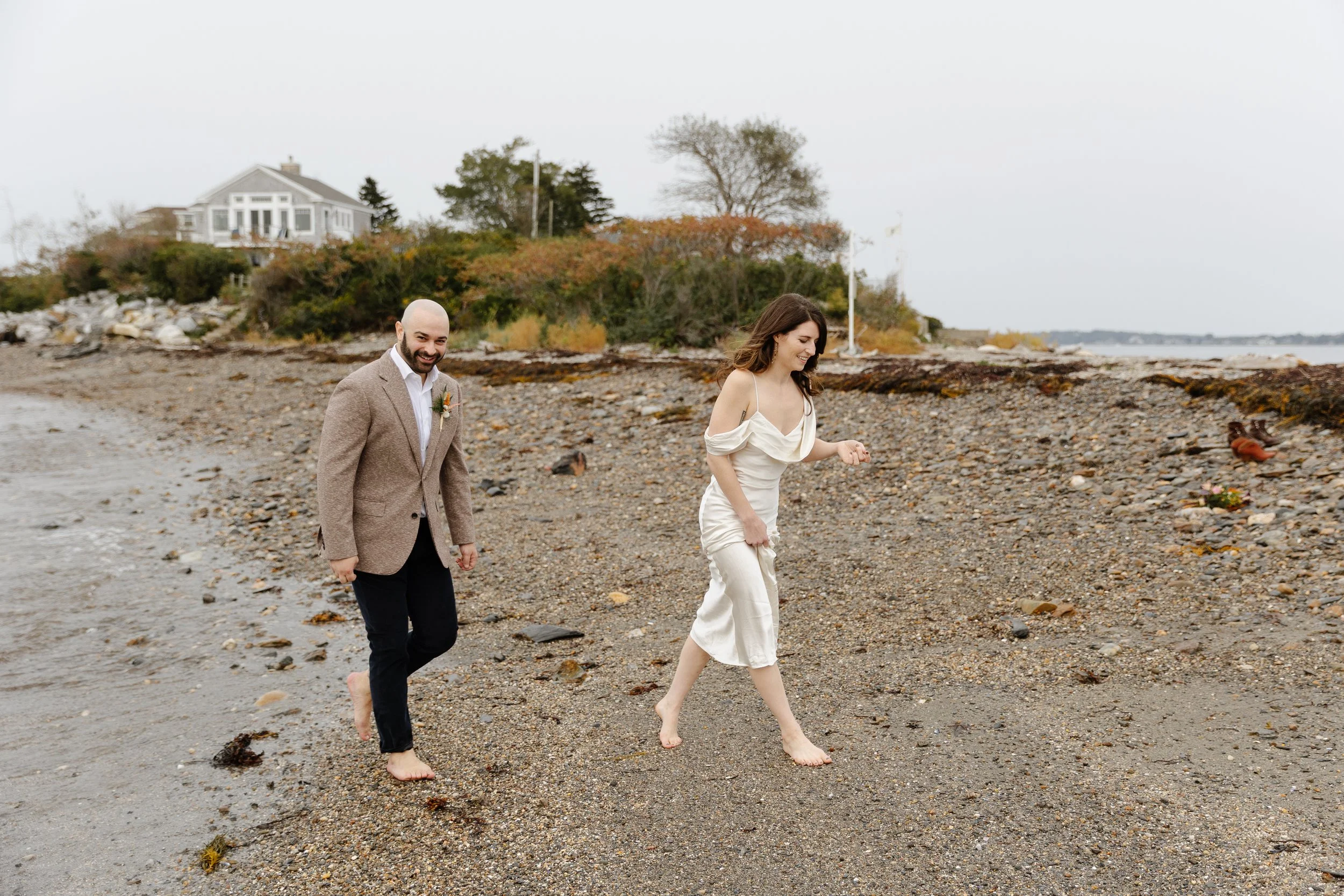 A couple walks the beach during their intimate and non-traditional wedding in Maine. Photography by Sienna Renee Photography.