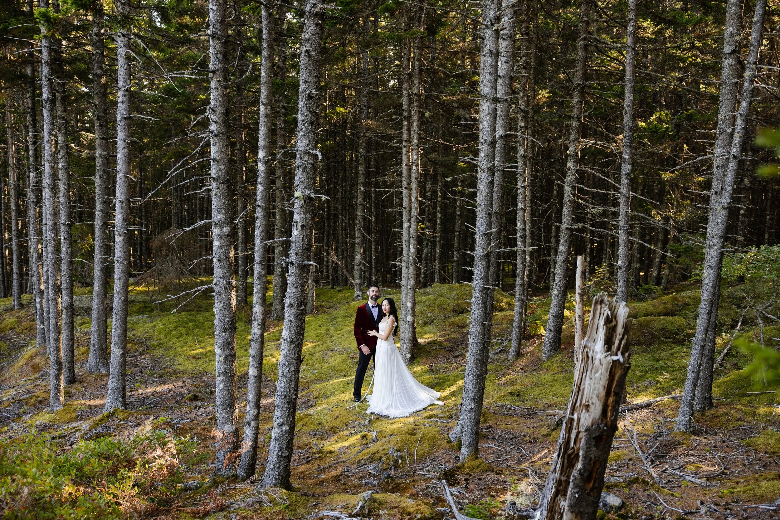 A couple stands in the woods during an intimate wedding weekend at Aragosta in Deer Isle, Maine. Photography by Sienna Renee Photography.