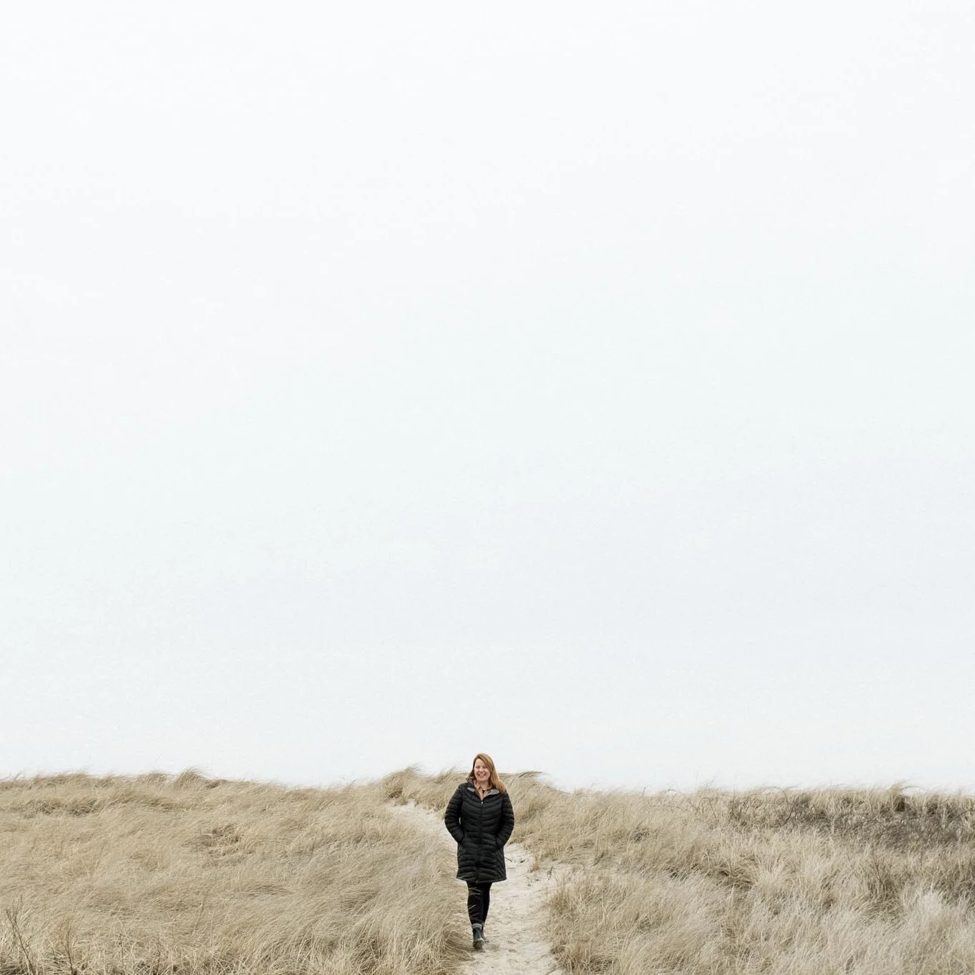 A girl stands in the grasses on Cape Cod, Massachusetts. Photography by Sienna Renee Photography.