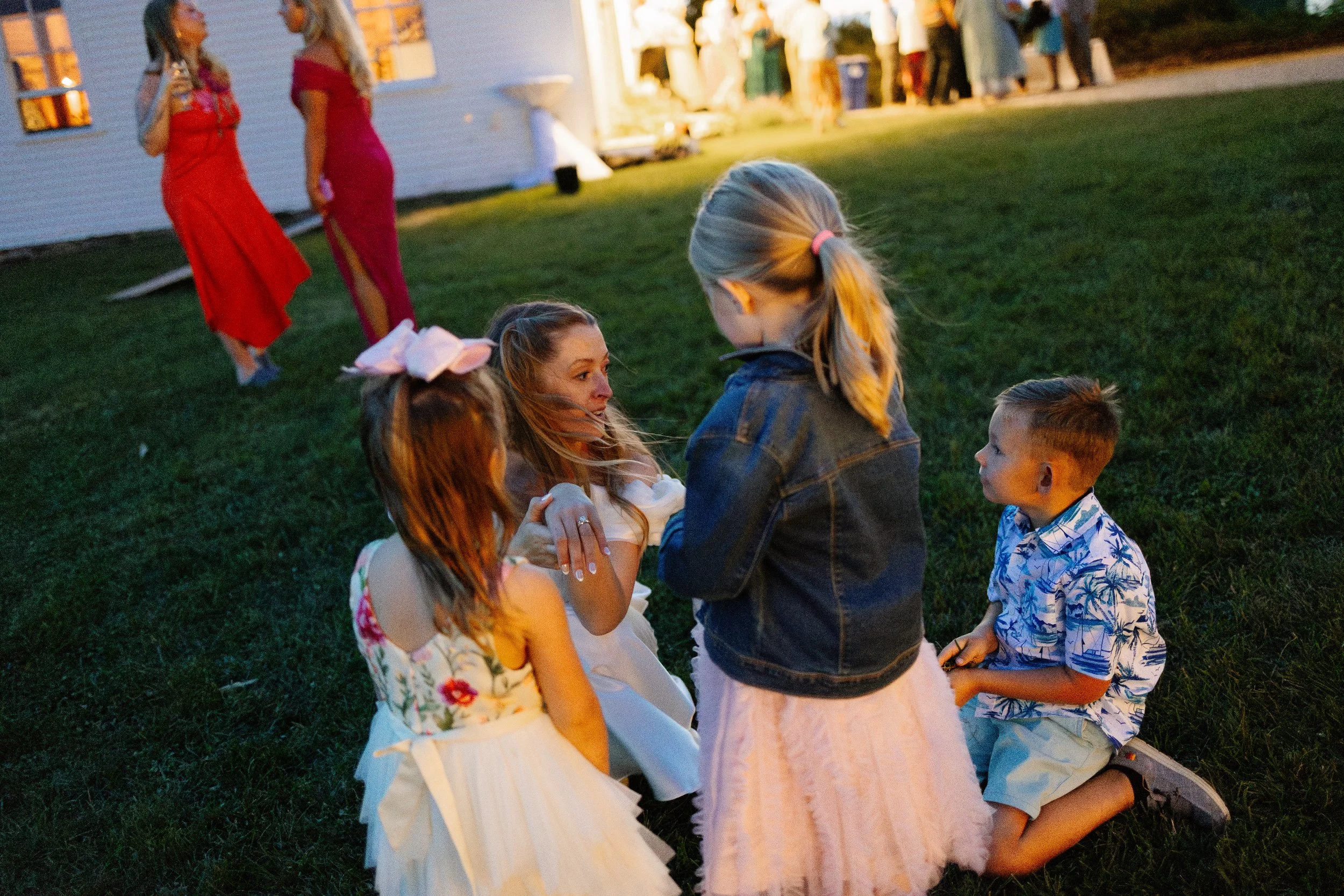 A bride during her wedding day with her family at Scotland Fields in York, Maine. Photography by Sienna Renee Photography.