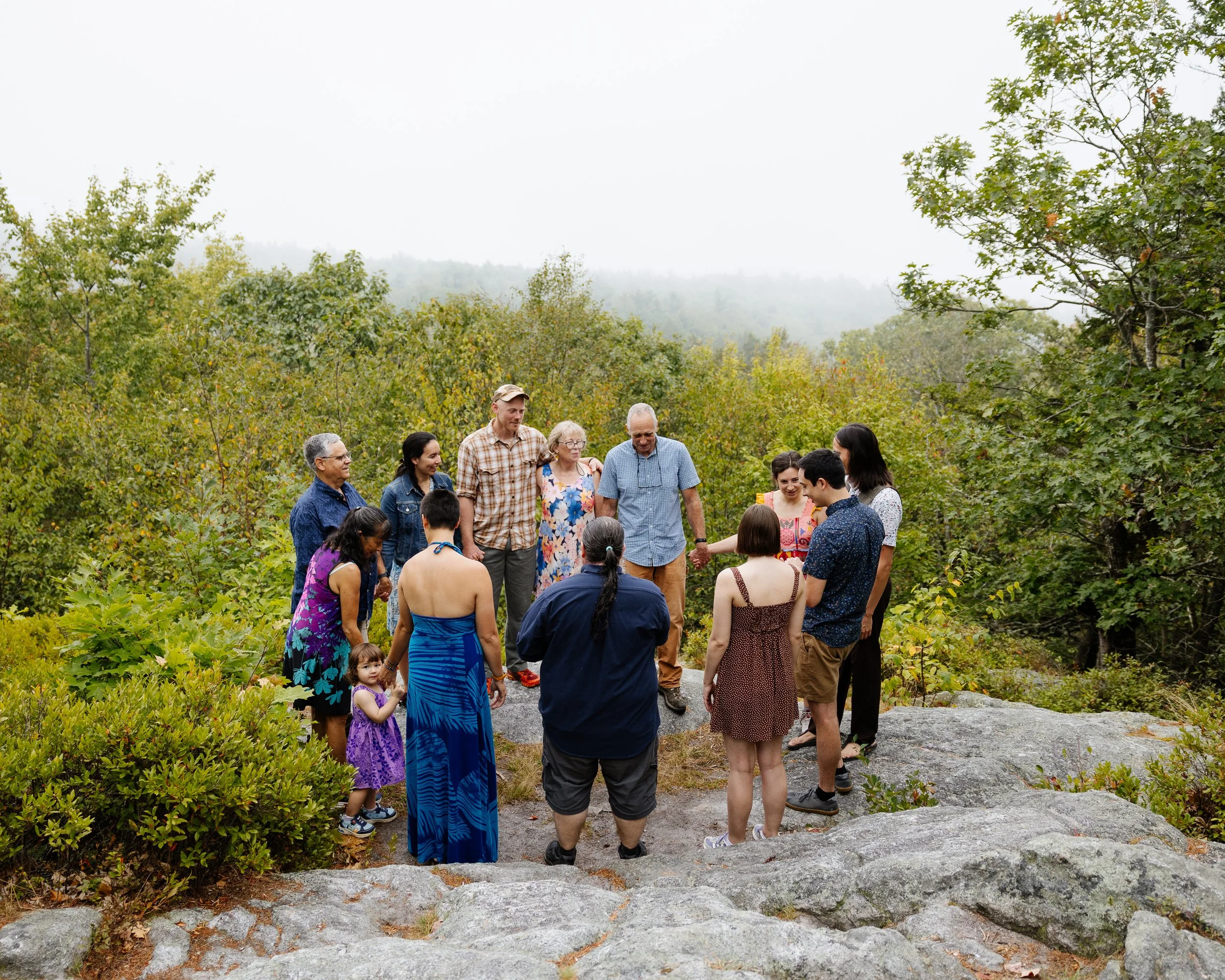 Family gather together during a hike on a wedding day in Maine. Photography by Sienna Renee Photography.