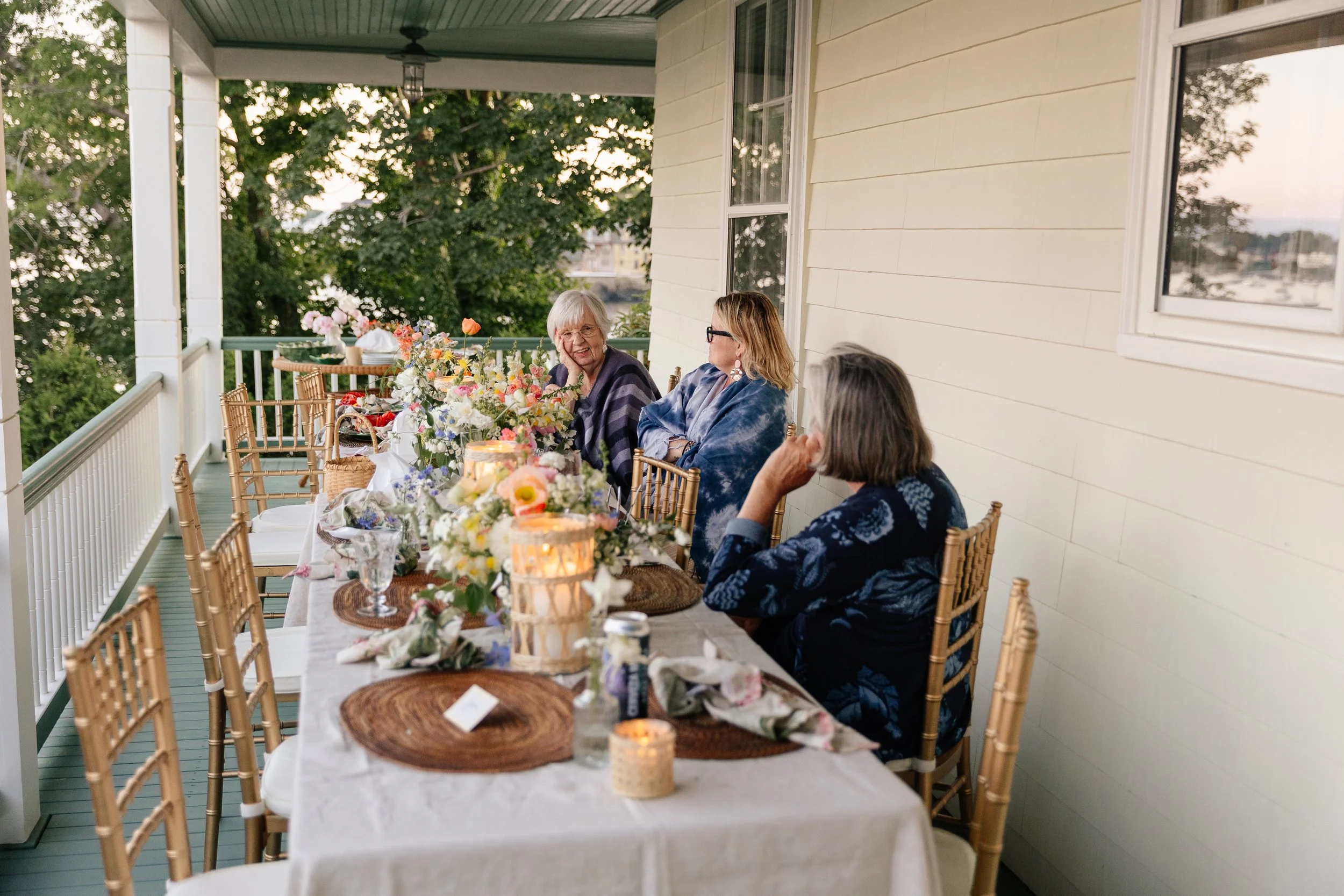 Family gathers at a table during a backyard wedding. Photography by Sienna Renee Photography.