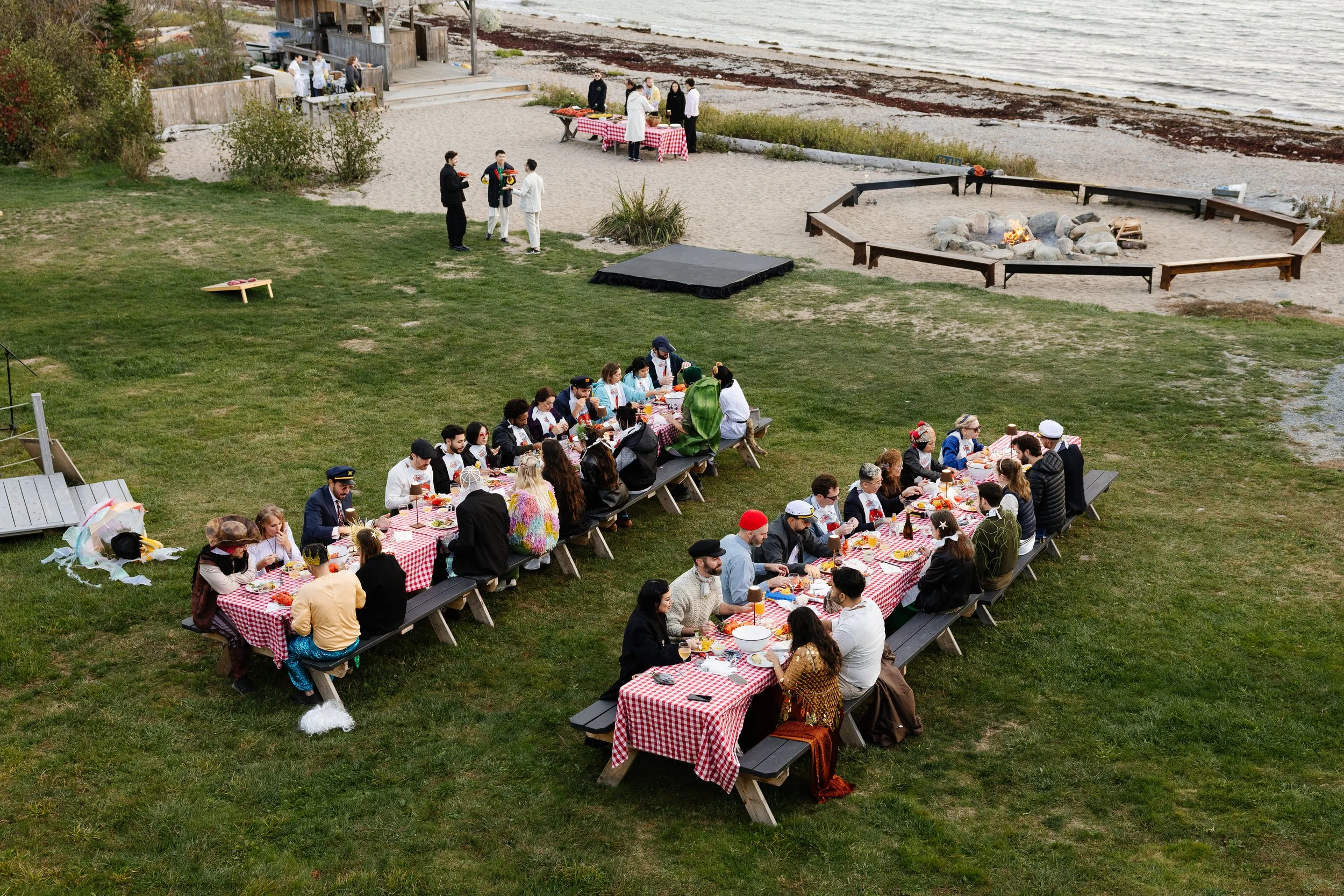 View of a lobster bake and costume party for a wedding weekend at Aragosta in Deer Isle, Maine. Photography by Sienna Renee Photography.