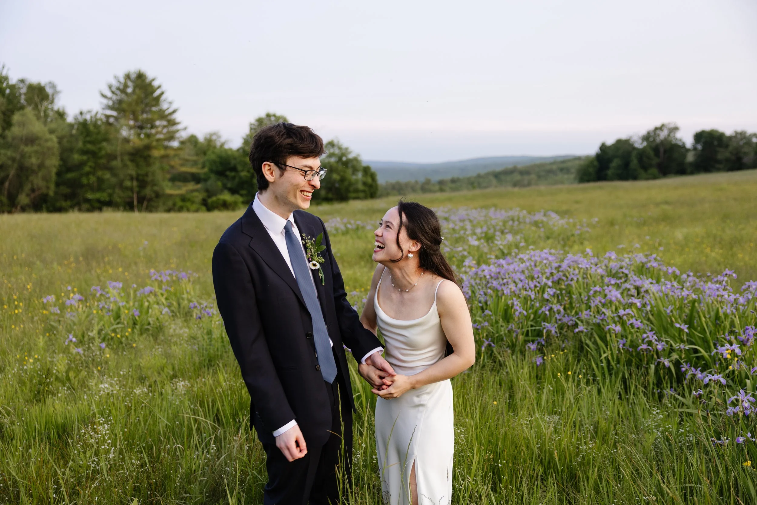 A couple laughs together during their backyard wedding in Norway, Maine. Photography by Sienna Renee Photography.