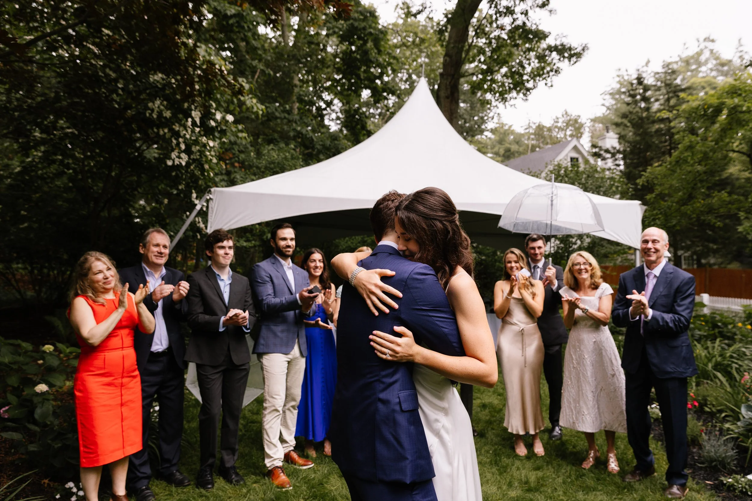 A couple hugs during their backyard intimate wedding with family. Photography by Sienna Renee Photography.