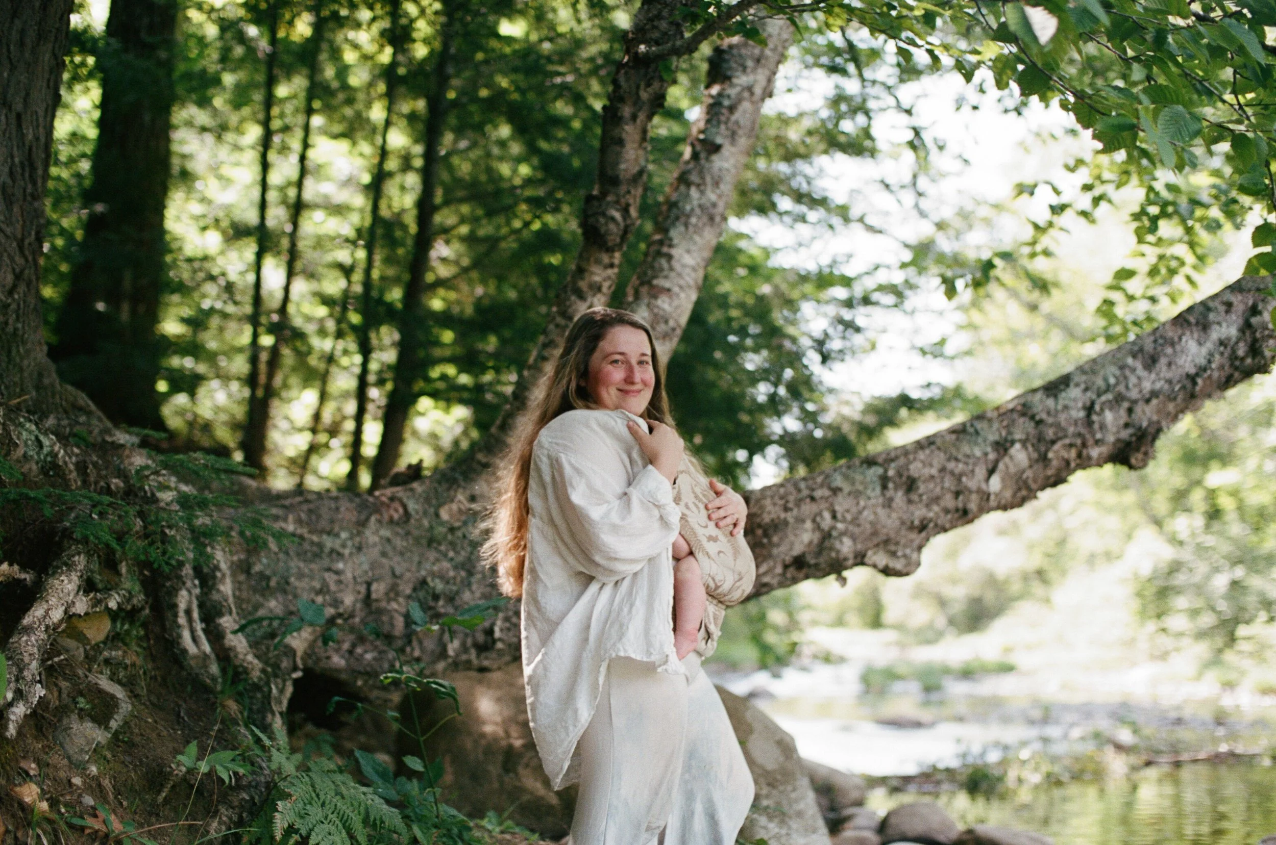 A mom holds her baby during a walk at home in Maine. Photography by Sienna Renee Photography.