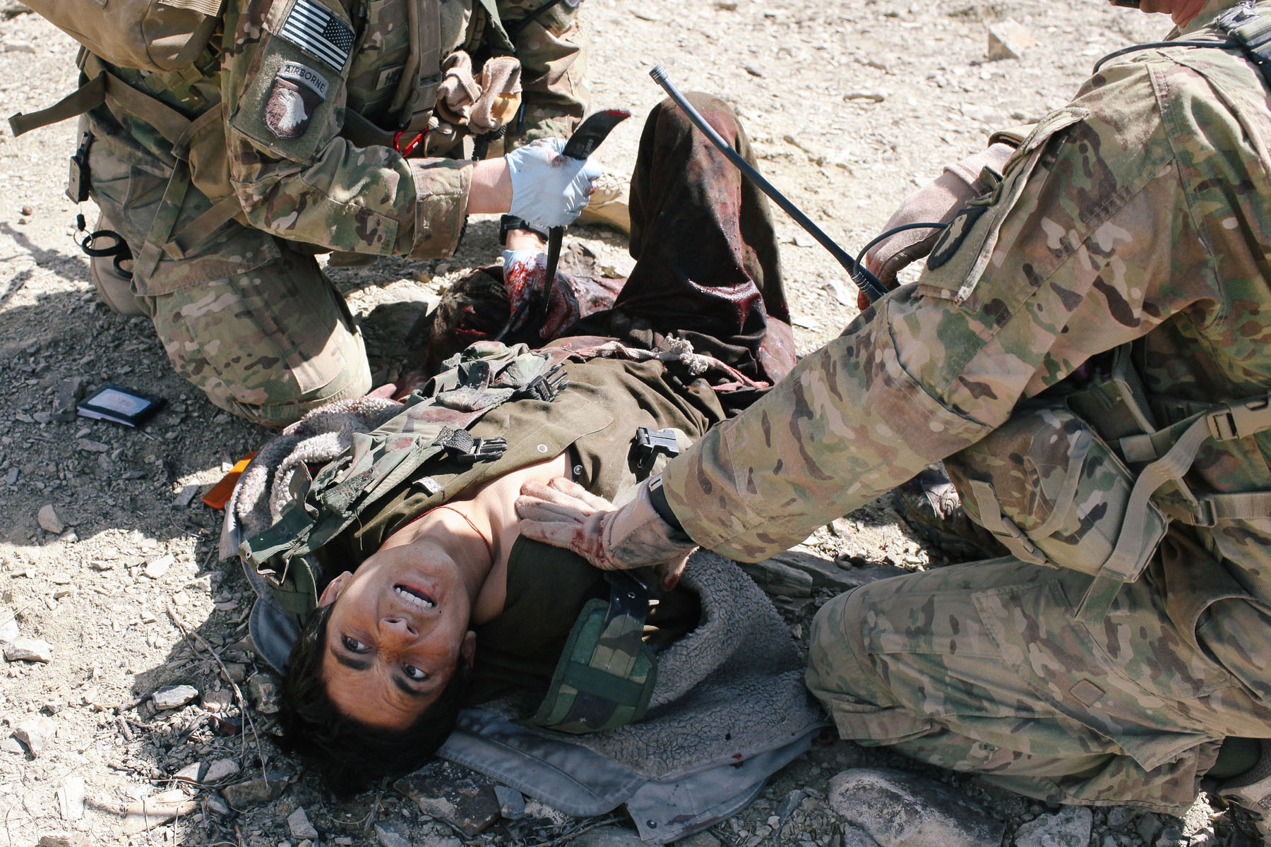 A medic works to stabilize a youth who was shot while attacking a fortified US outpost with an AK-47 and a pistol. He was airlifted to a larger base on order to receive advanced medical care.