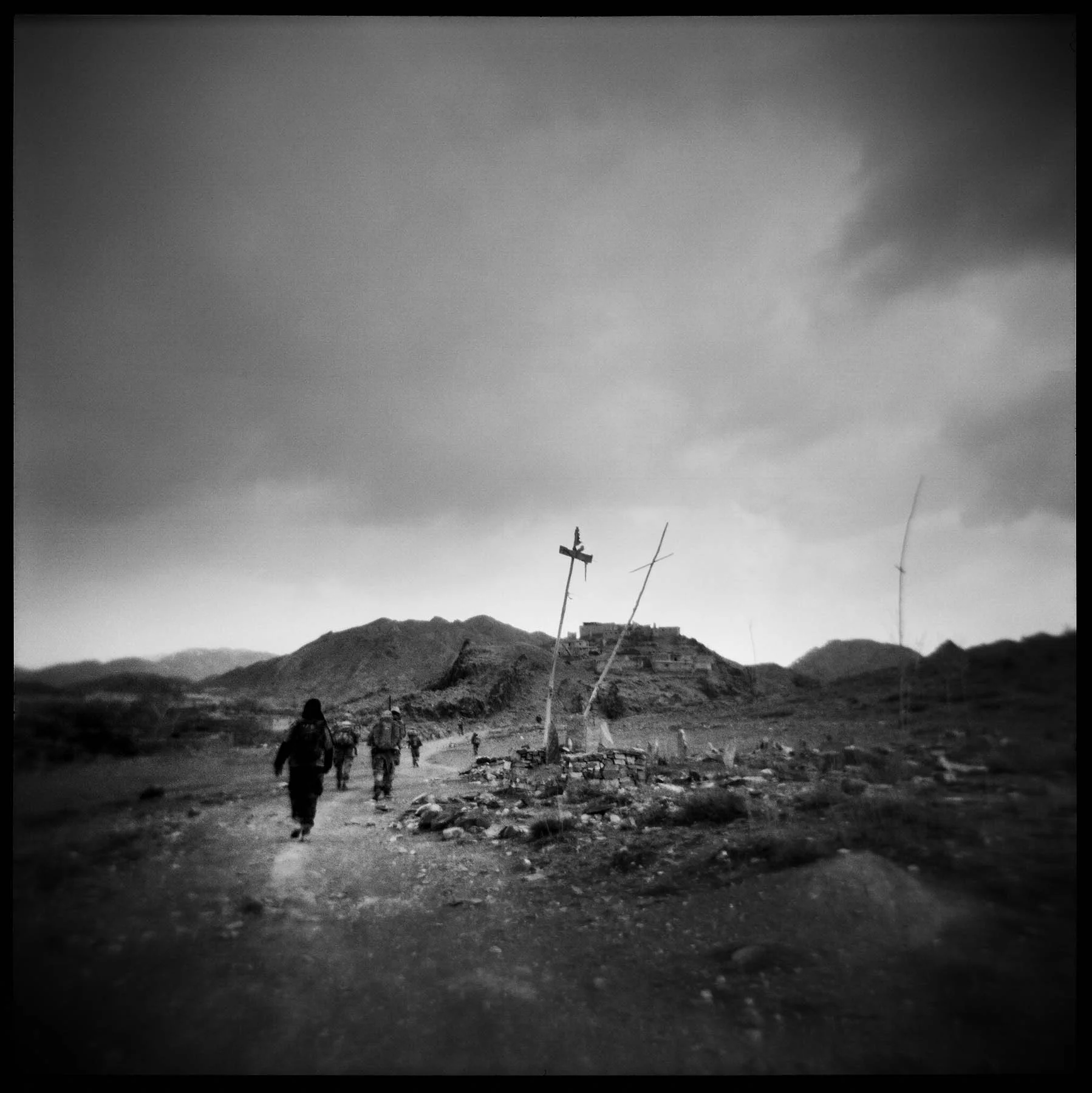 Soldiers pass a local graveyard while on patrol in the Gayan Valley. Paktika, 2011.