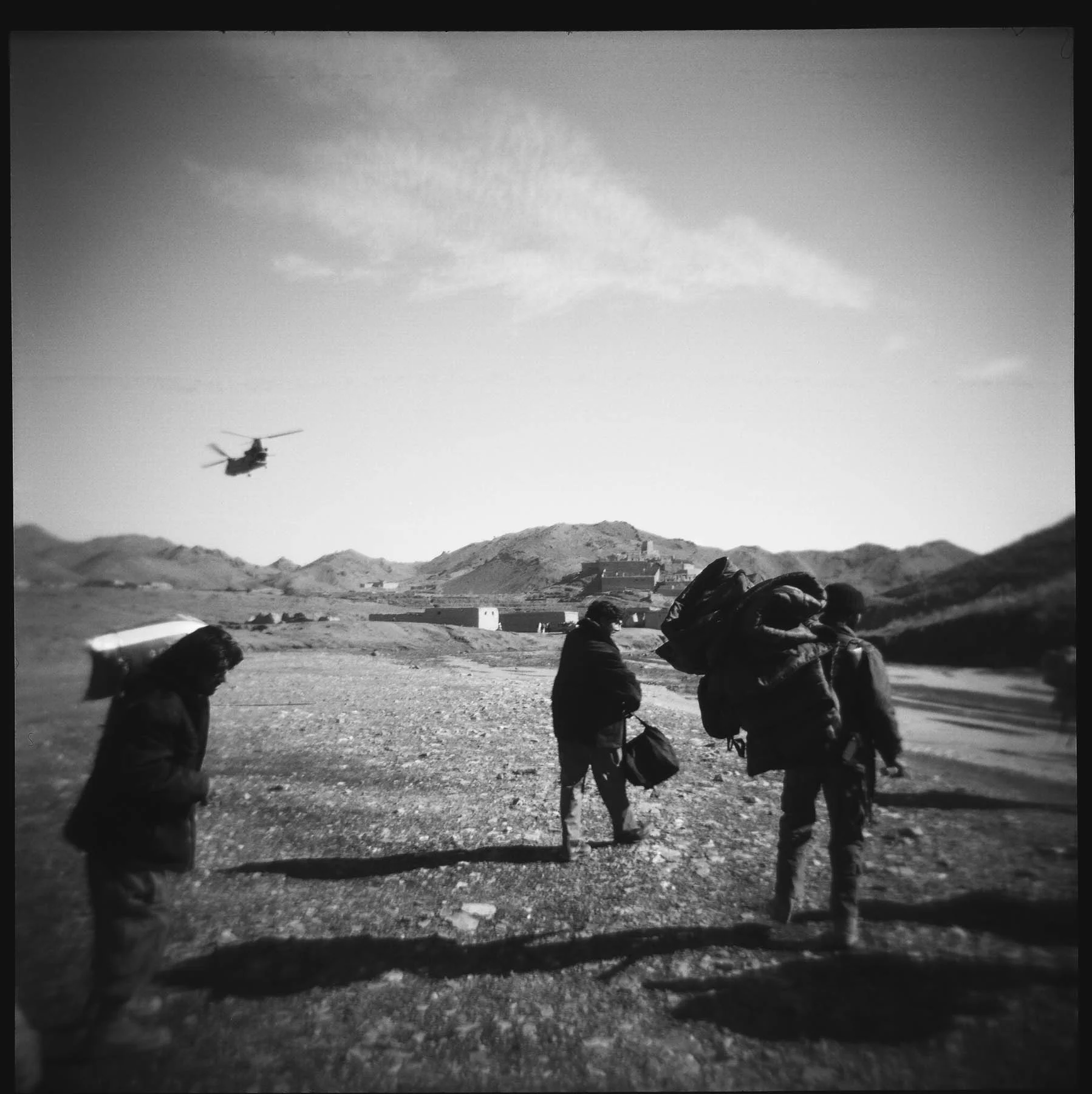 Afghan National Army soldiers shoulder supplies after being dropped off by helicopter during a joint mission with US forces. 2011.