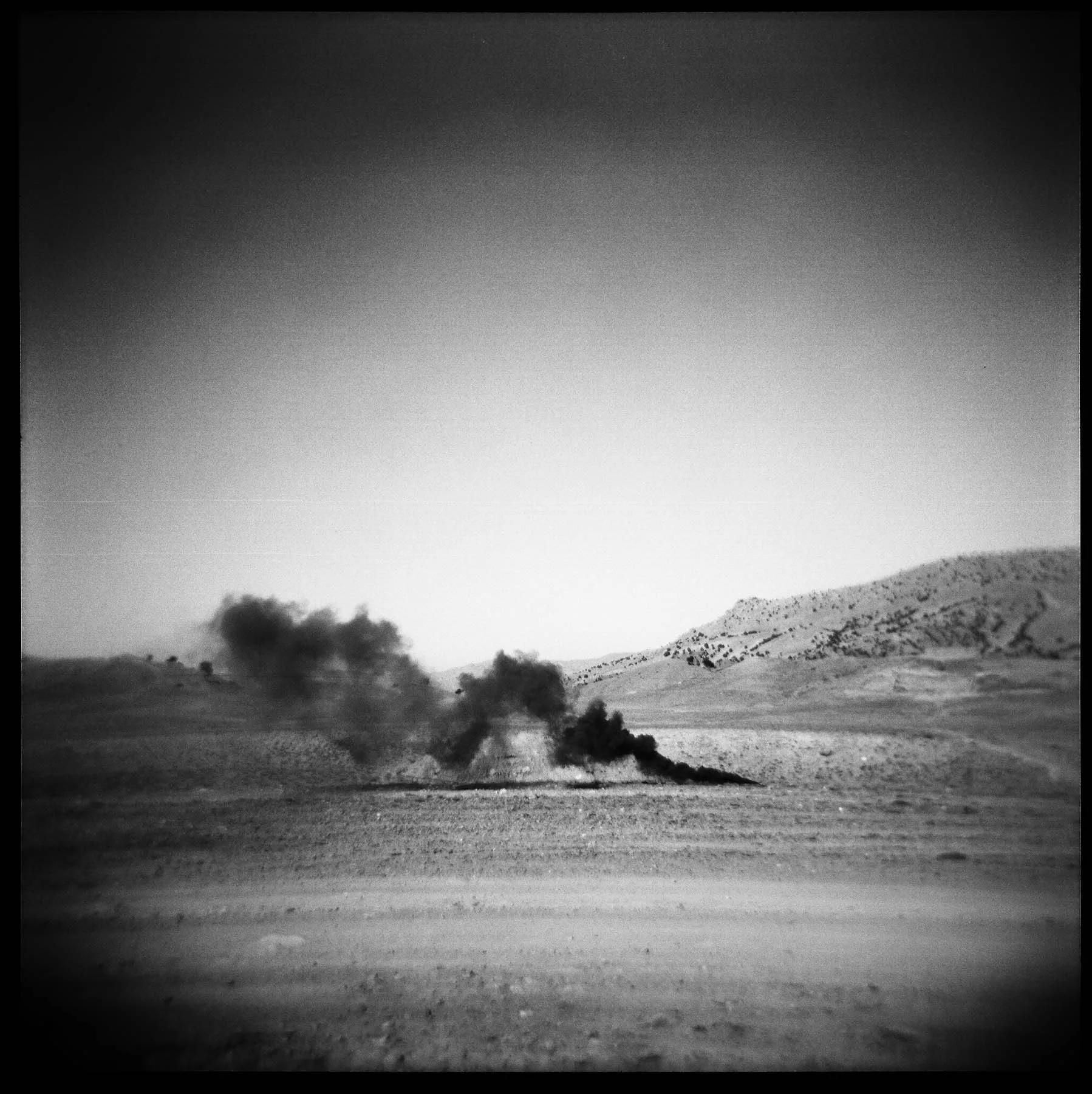 A smoke flare marks the landing zone for supplies to be dropped from a plane near FOB Tillman on the Af-Pak border of Gayan district, Paktika province. 2011.
