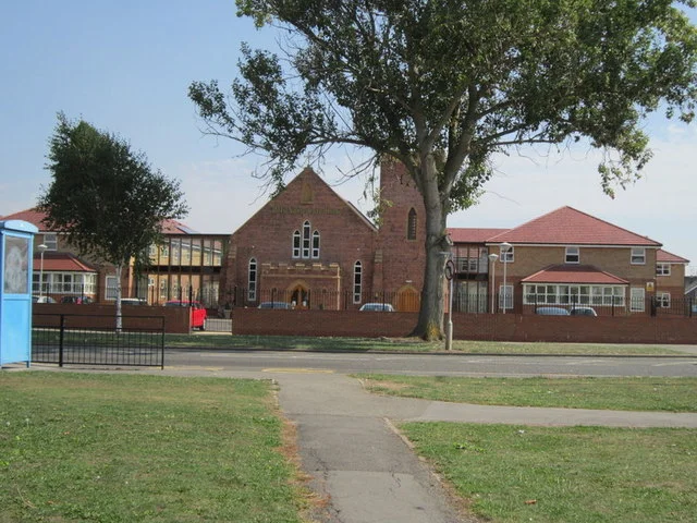 EXISTING CHURCH WITH NEW BUILDING WRAPPED AROUND IT 