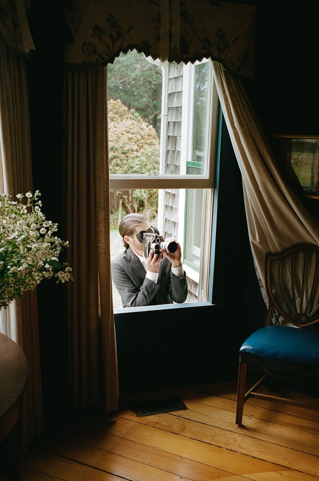 Wedding videographer films on 16mm camera at estate on Cape Cod