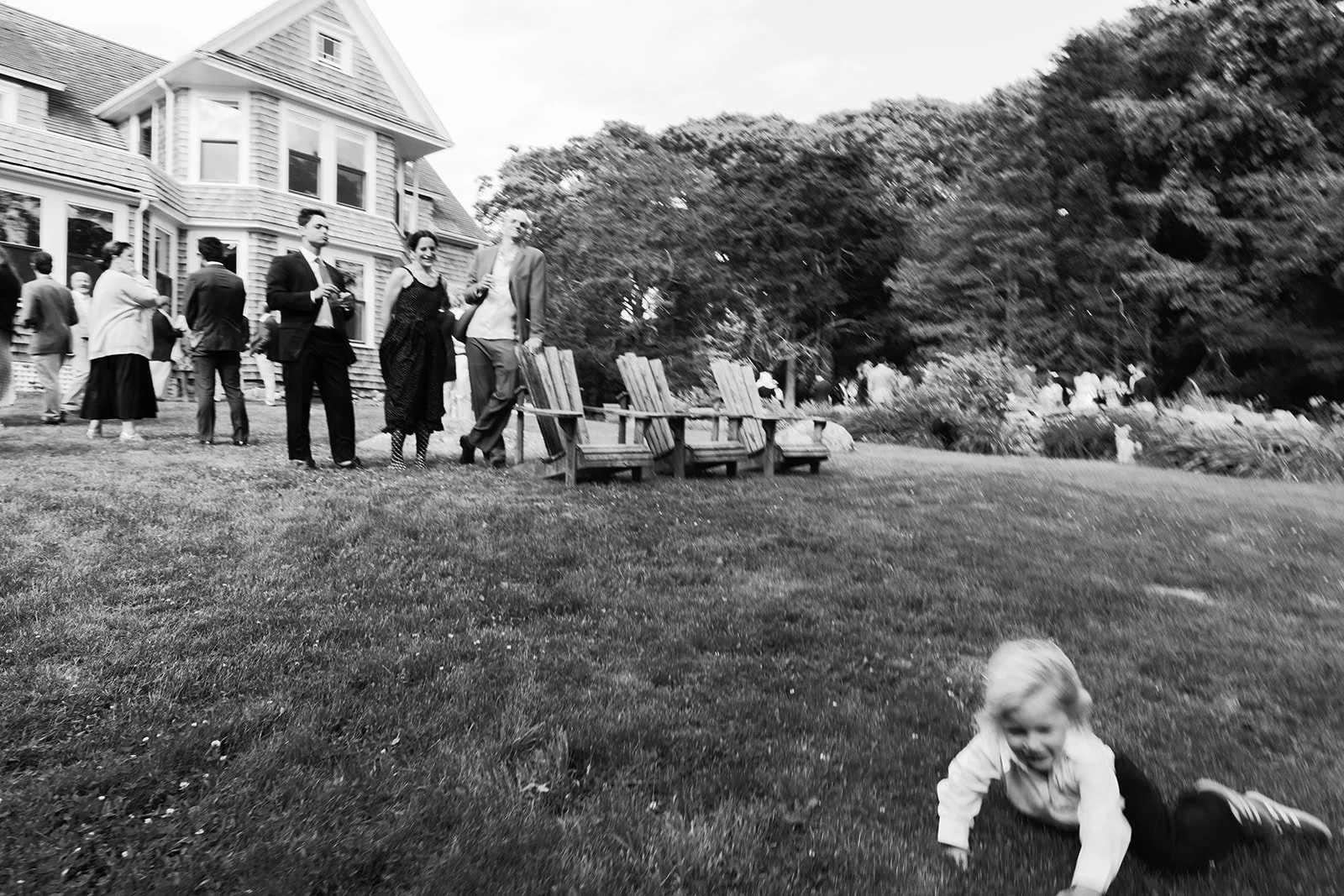Guest at wedding rolls down a hill in Caoe Cod, Massachusetts.