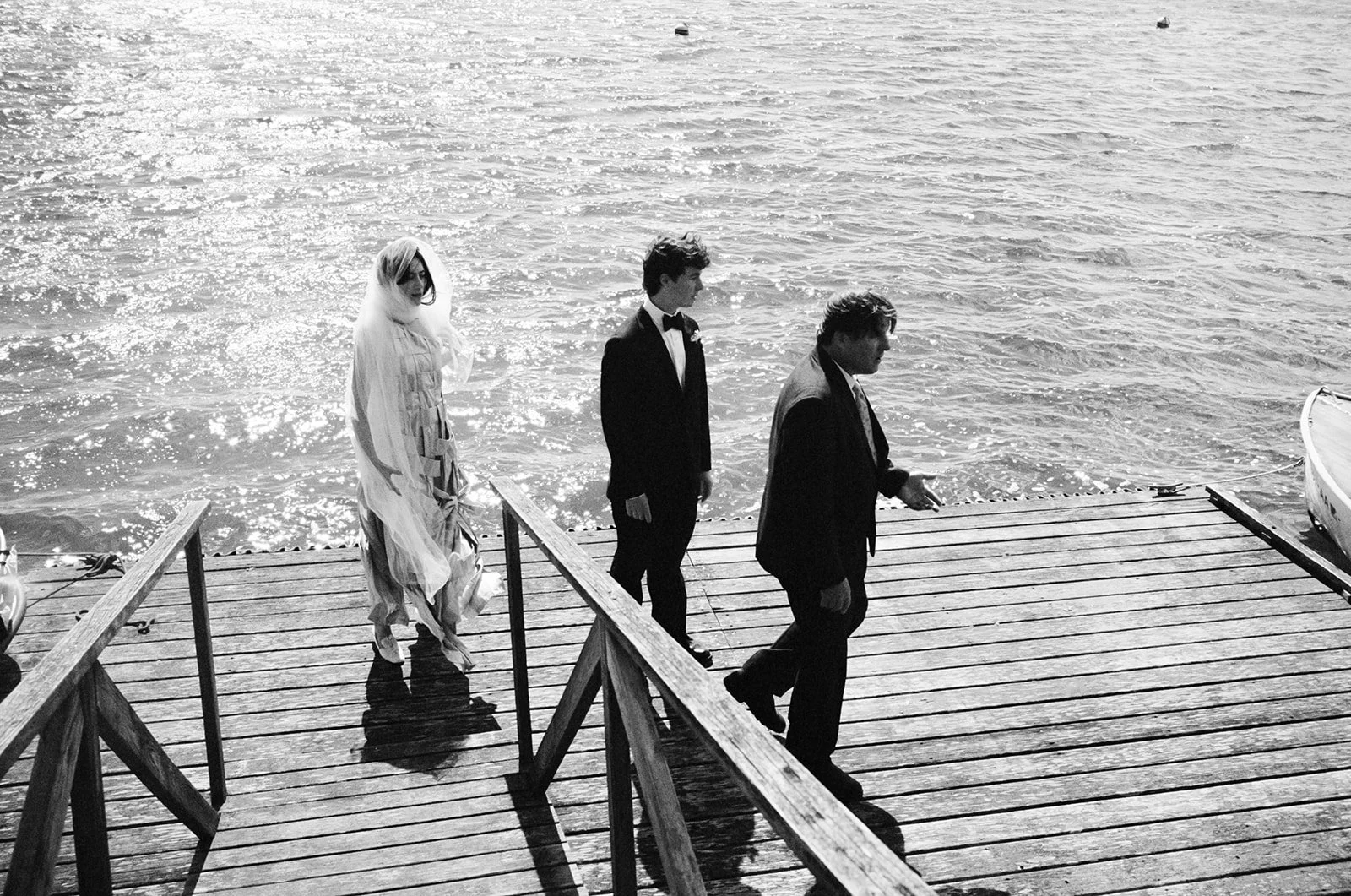 Wedding couple walk along a dock on the water of Cape Cod, Massachusetts
