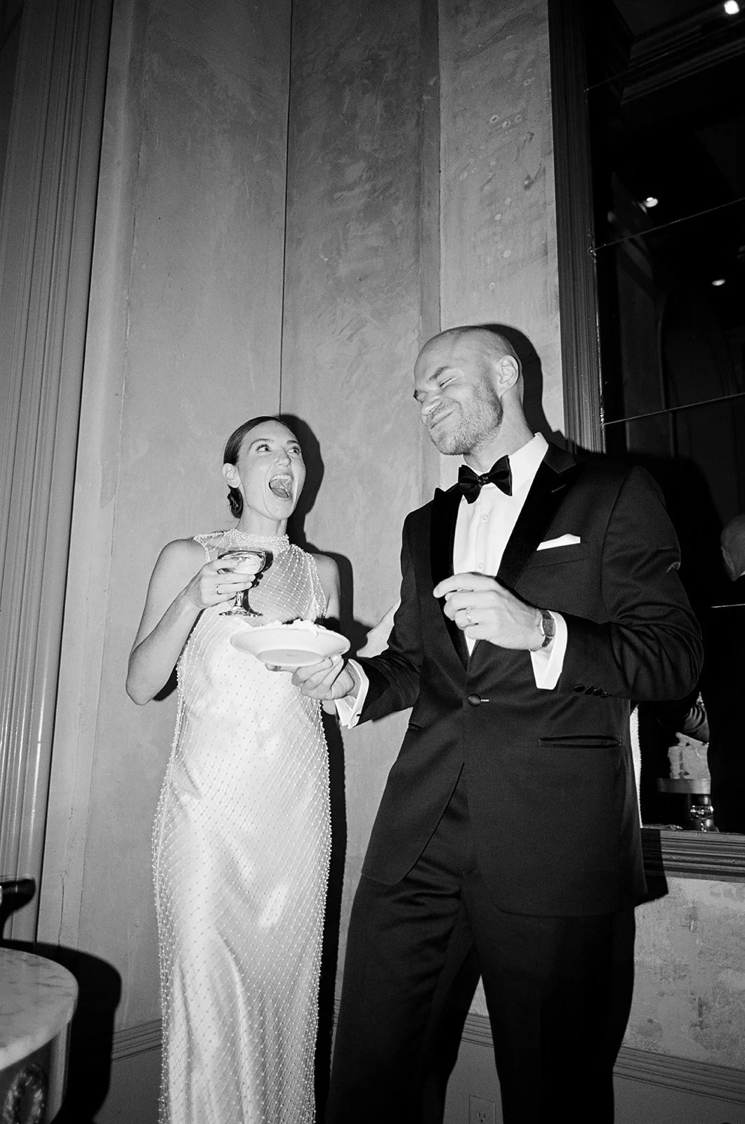 Bride and groom laugh after cutting the cake at their wedding reception in Savannah, Geogria.