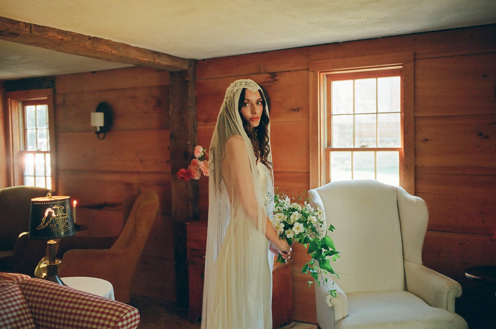 Bride poses in woodshed of Stissing House on her wedding day in Hudson, New York.