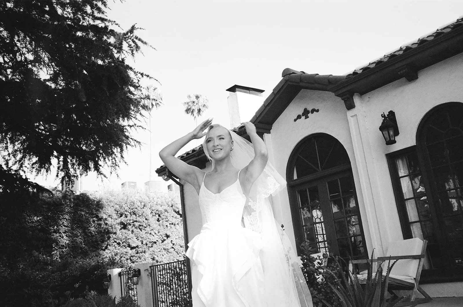 Bride poses for wedding portrait outside of home in Los Angeles, California.