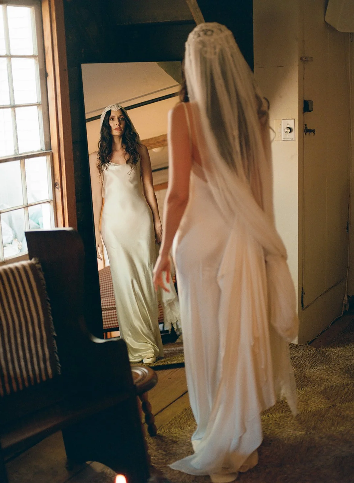 Bride looks in mirror inside woodshed of Stissing House in Hudson, New York.