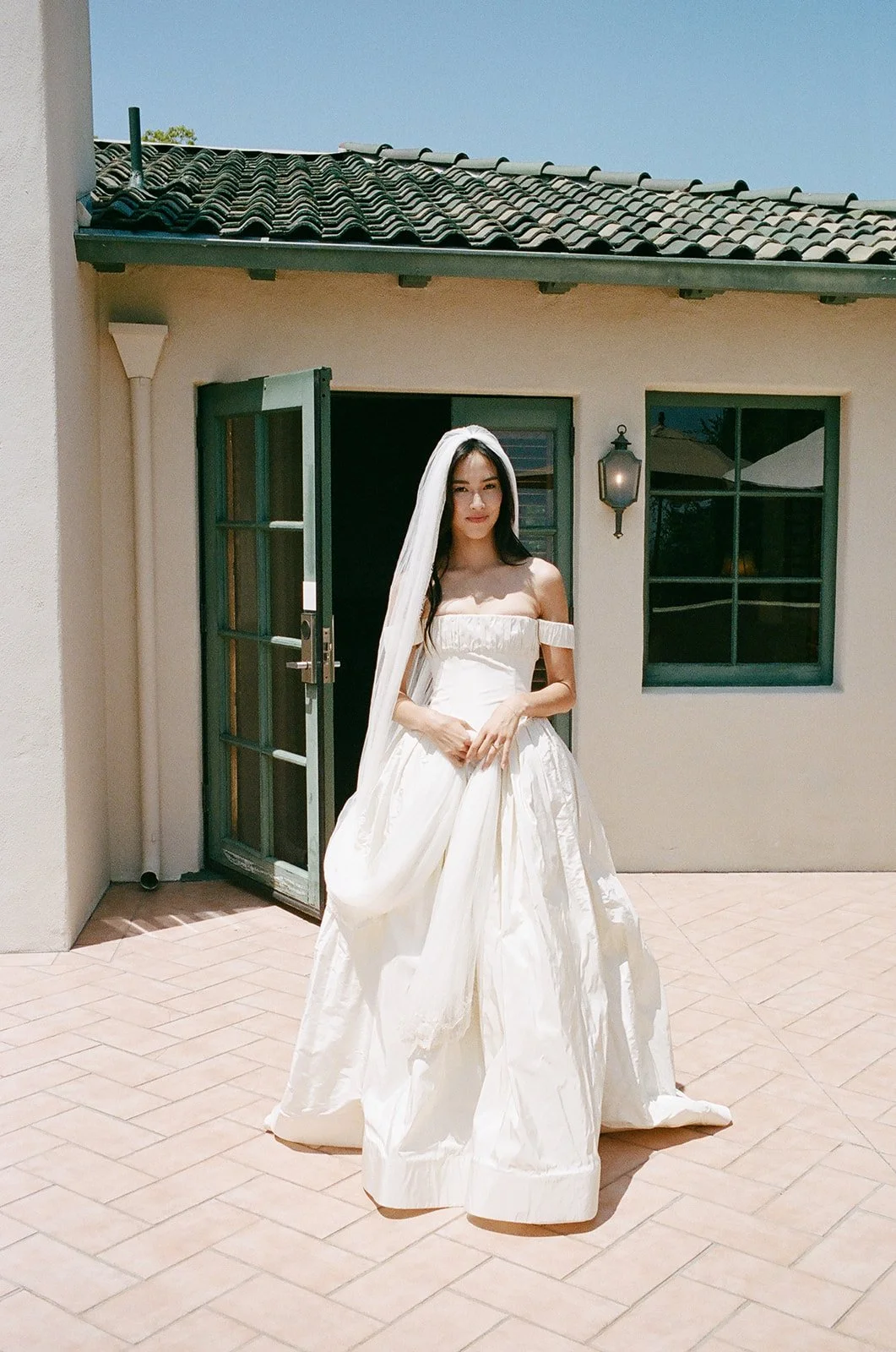 A bride poses for a film portrait in her Cinq gown at the Langham Hotel in LA, California.