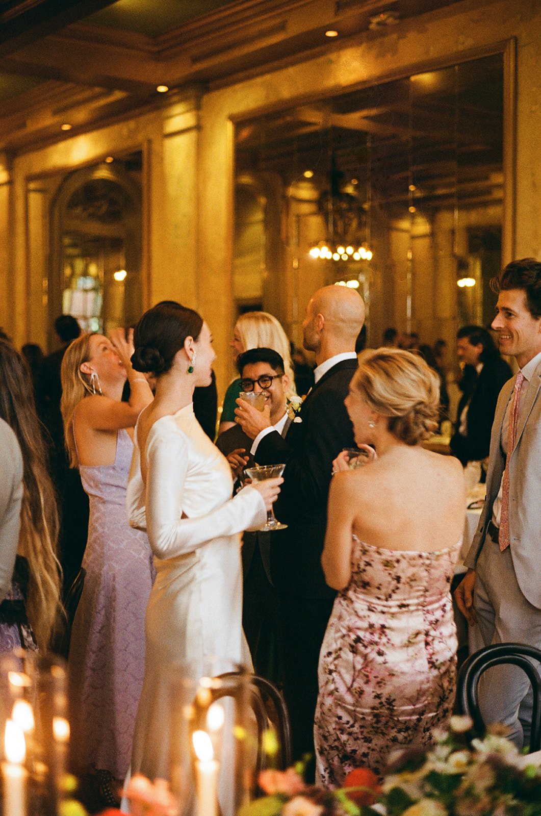 Bride wearing Danielle Frankel gown talks with guests in glowing candlelit ballroom of Savannah, Geogria.
