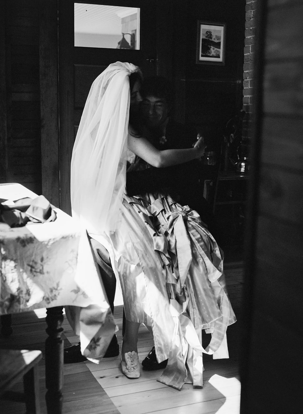 A bride and groom sit for a film portrait just before their ceremony in the woods of Falmouth Cape Cod in Massachusetts.