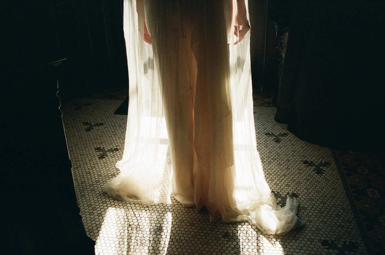 Custom wedding veil glows with sunlight as bride poses at The Maker Hotel in Hudson, New York.
