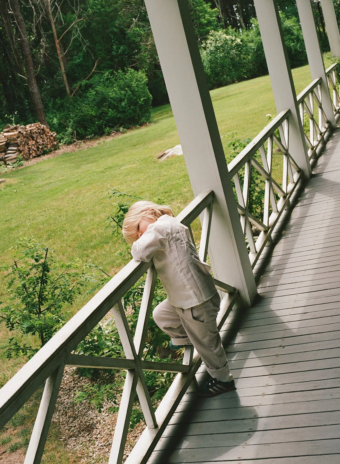 A young wedding guests waits along the porch for the wedding ceremony to begin at a wedding on Cape Cod, Massachusetts.