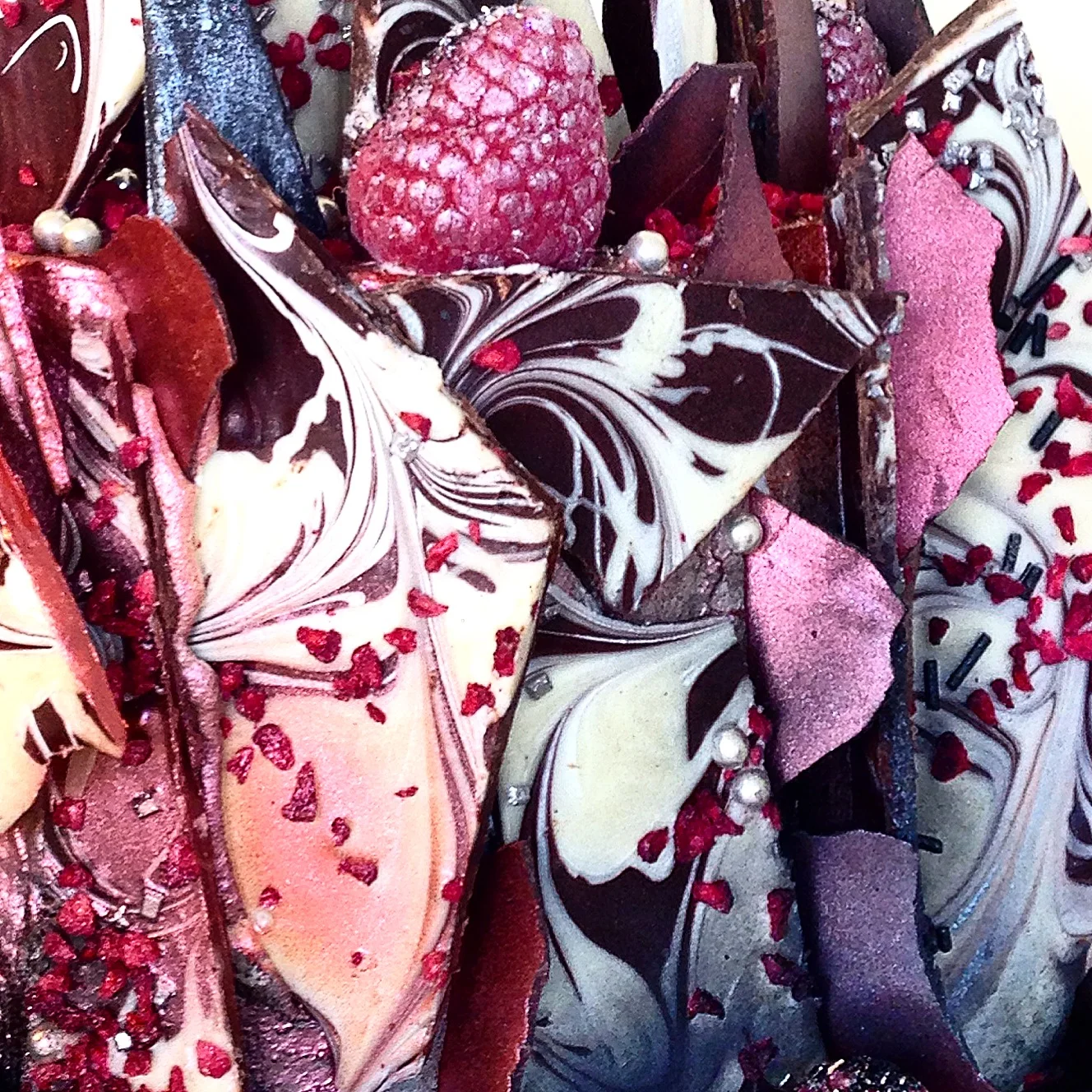  Marbled tempered chocolate layers, freeze dried raspberries, fondant shards &amp; fresh glittered raspberries - Thunderbolt &amp; Lightning cake close up. 