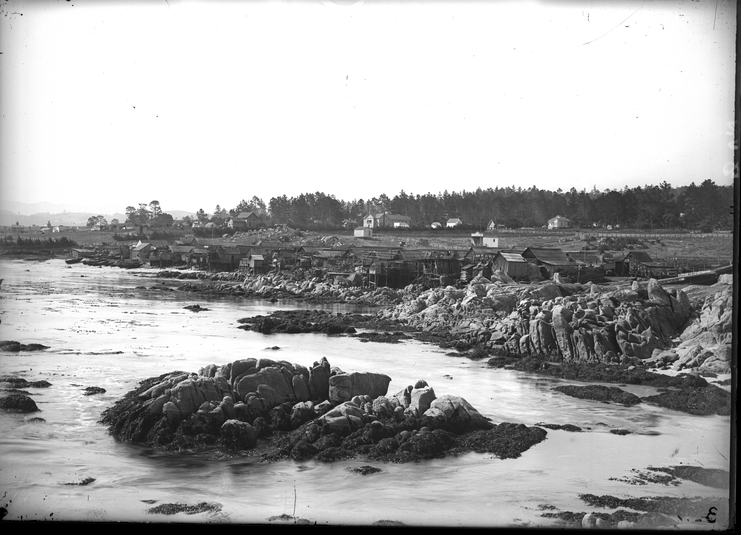Shoreline sweep of Chinese village and proximity to Pacific Grove houses into new Monterey. One of the Pacific Grove Retreat gates is is visible at center of image.