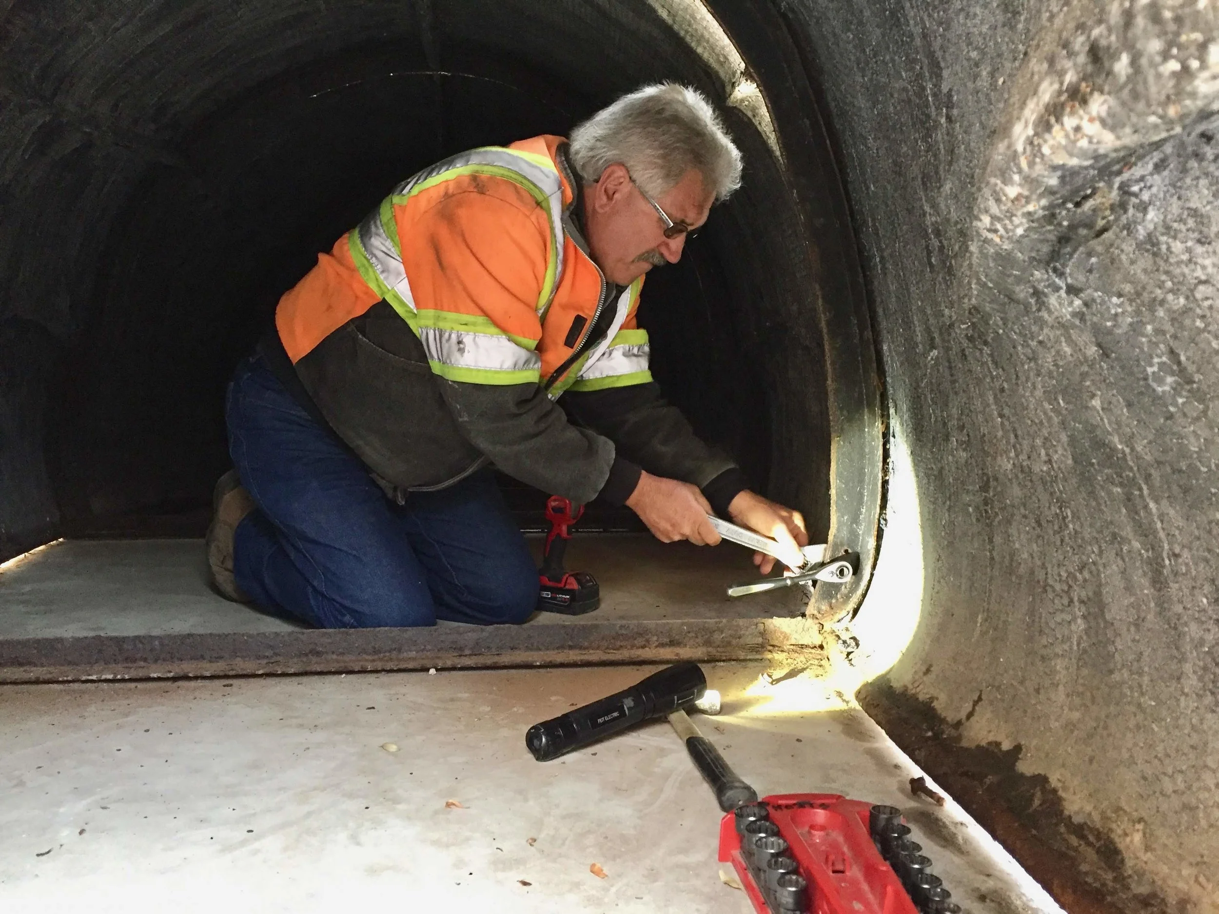 Linseed oil was applied to Sandy’s surface one week before the work was started. Roque Pinheiro, Public Works (PW) Buildings & Grounds Supervisor had performed maintenance on the sculpture since it’s arrival in 1981 and led the PW crew. This photo shows him “in the belly of Sandy” working on disassembly.