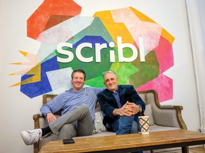 Jeff and his co-founder Matt Kaplan sitting in front of the Scribl sign