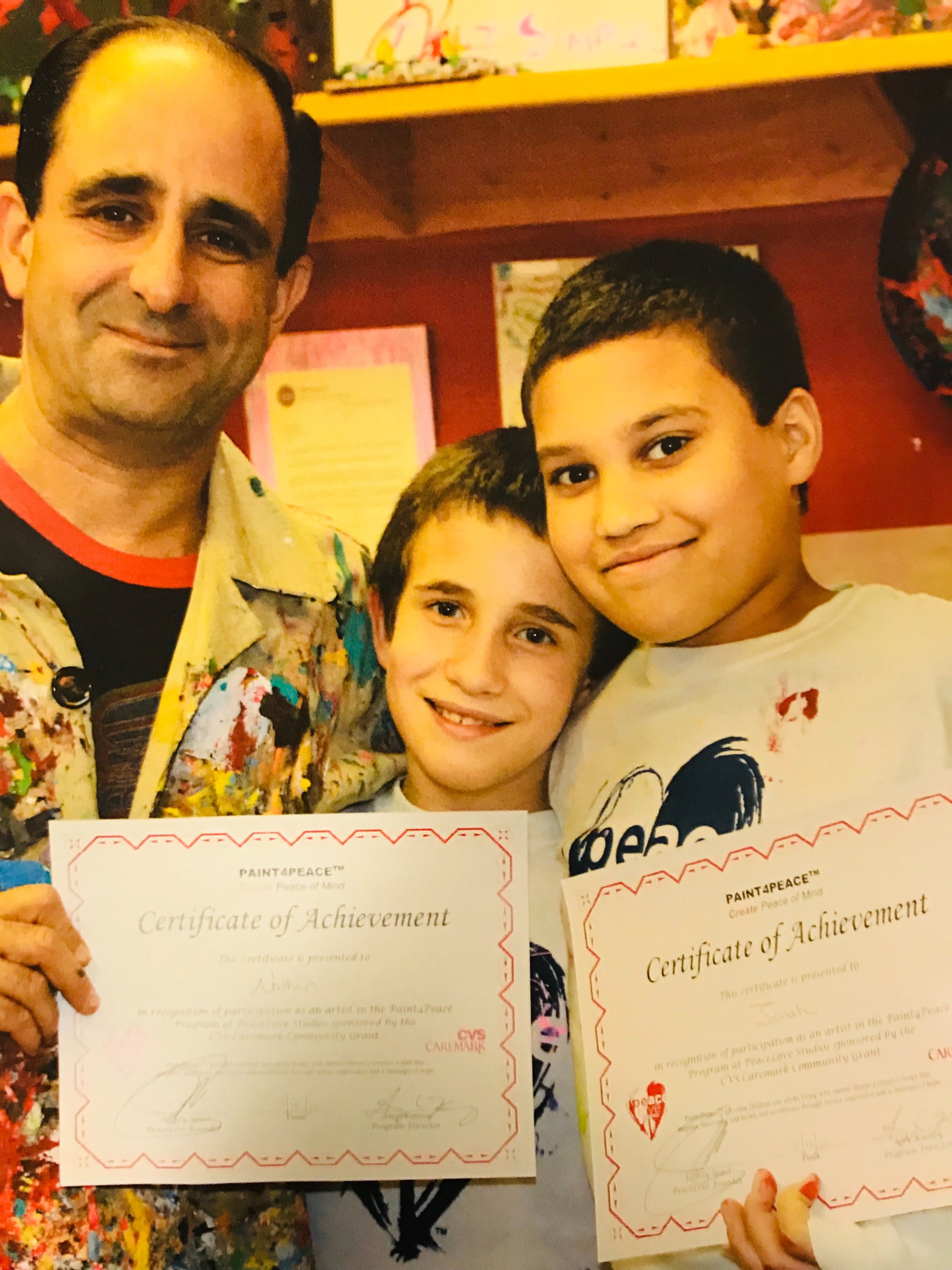 Jeff Sparr with two kids holding Certificate of Achievement awards from PeaceLove.