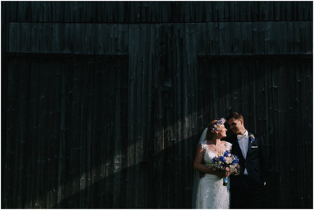 Brautpaar vor einer Holzhütte