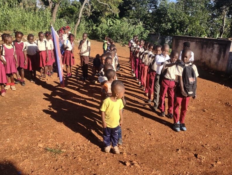 Students salute their flag and prepare to start another day of learning.