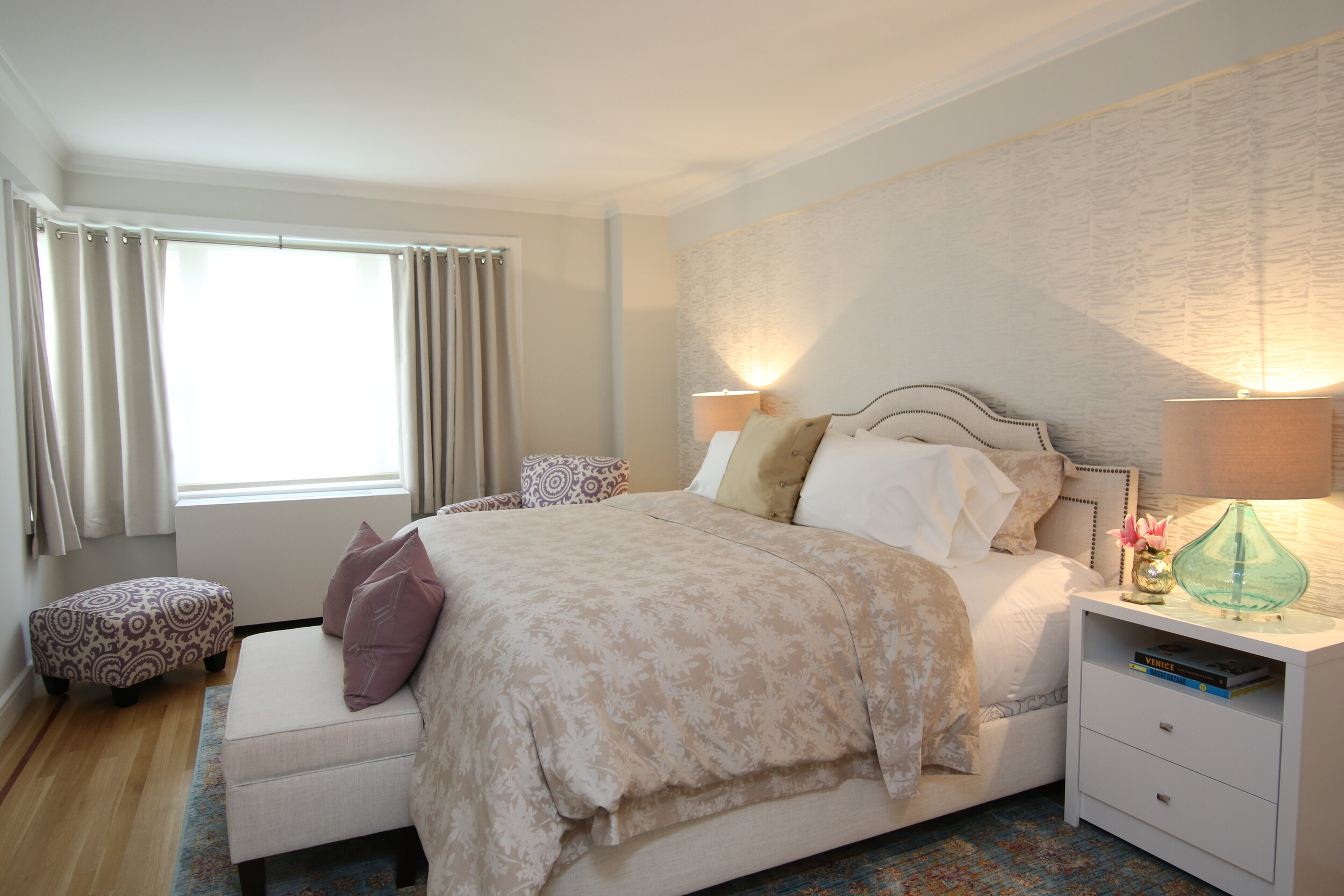 Upper east side master bedroom with luxurious linens and textured wallpaper 