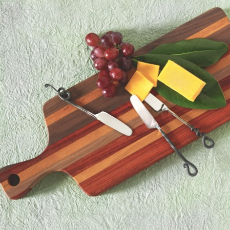 This Authentic Fair Trade cutting board was ethically sourced and handmade in Cameroon. One of this product's contributing craftsmen is Njinuwo Richard, who wants to run his own workshop someday. This design is unique for its incorporation of many different wood colors. 